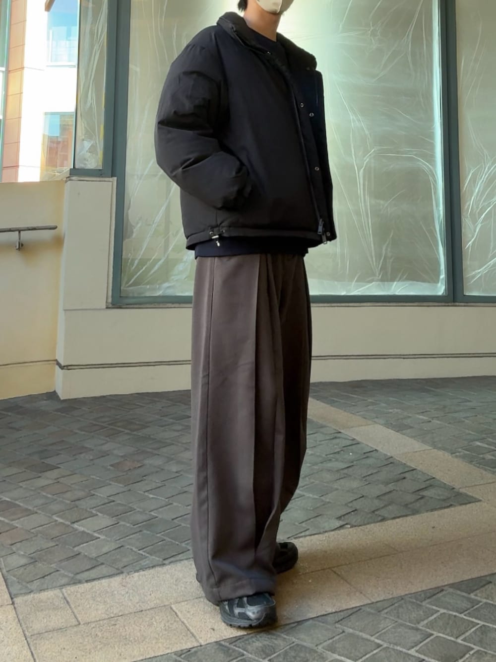 グレー系のダウンジャケット/コート、ブラック系のスウェット、ブラック系のスニーカーを着用したメンズの冬コーディネートの2枚目の写真