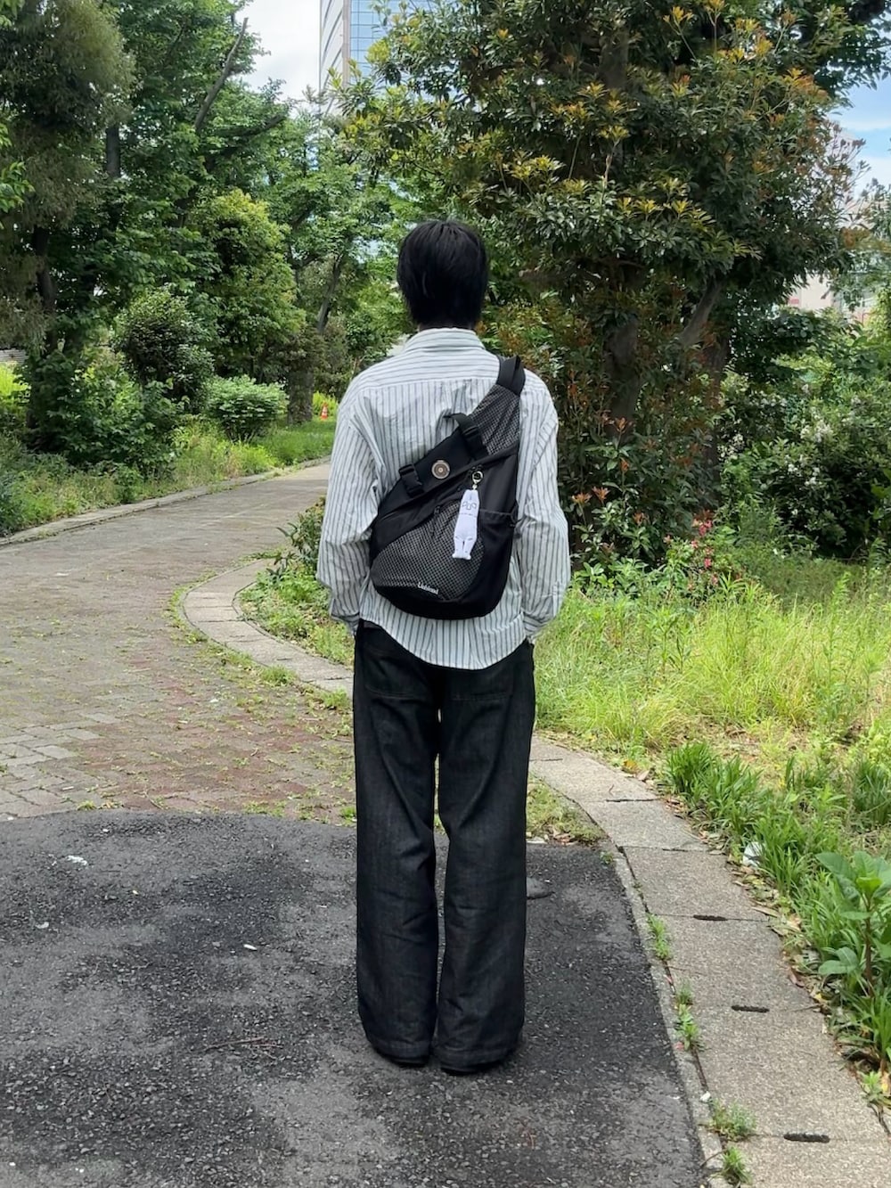 ブルー系のシャツ/ブラウス、ブラック系のデニムパンツ、ブラック系のスニーカーを着用したメンズの春コーディネートの3枚目の写真