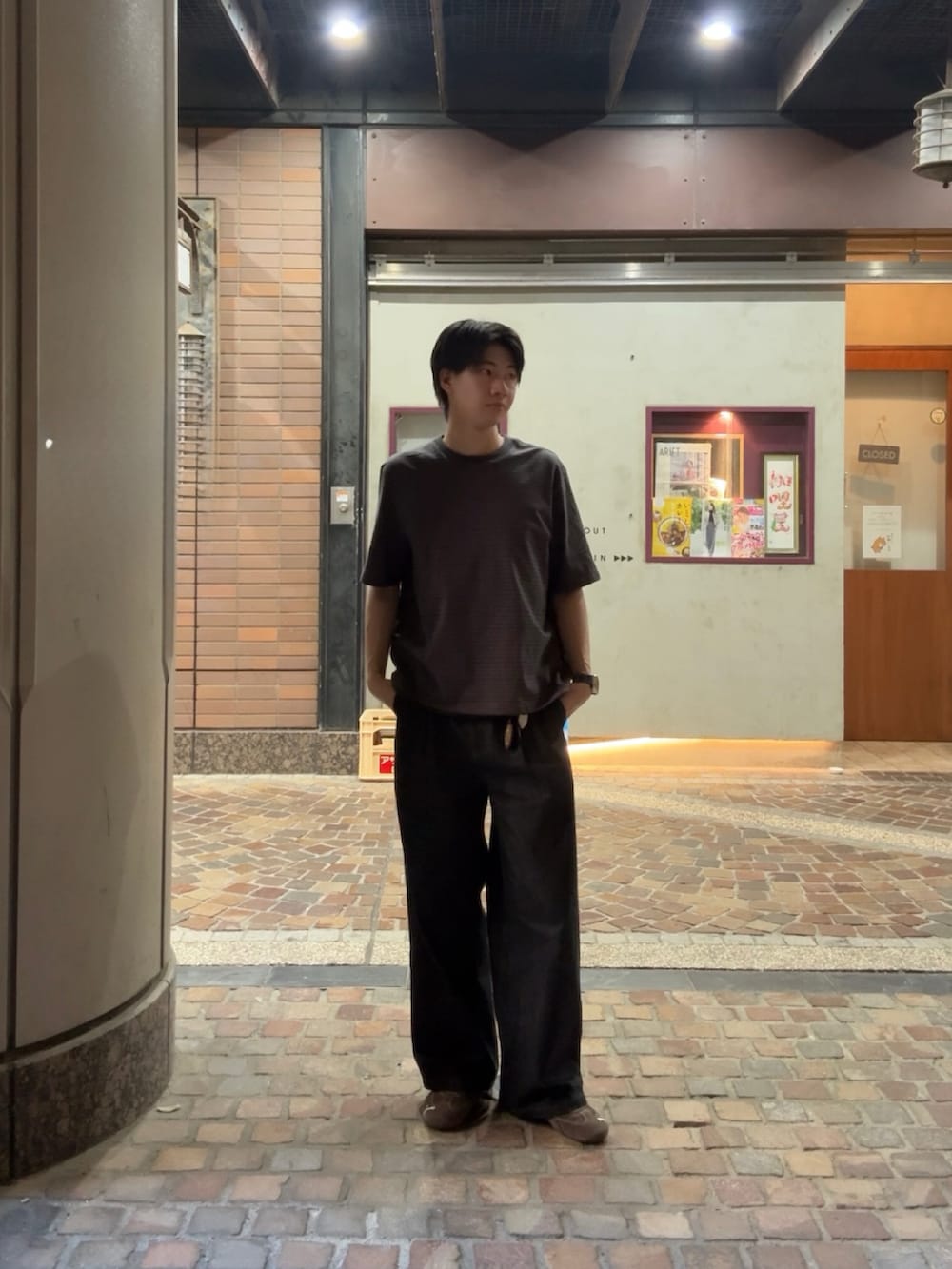 グレー系のTシャツ/カットソー、ブラック系のデニムパンツ、ブラウン系のスニーカーを着用したメンズの春コーディネートの3枚目の写真