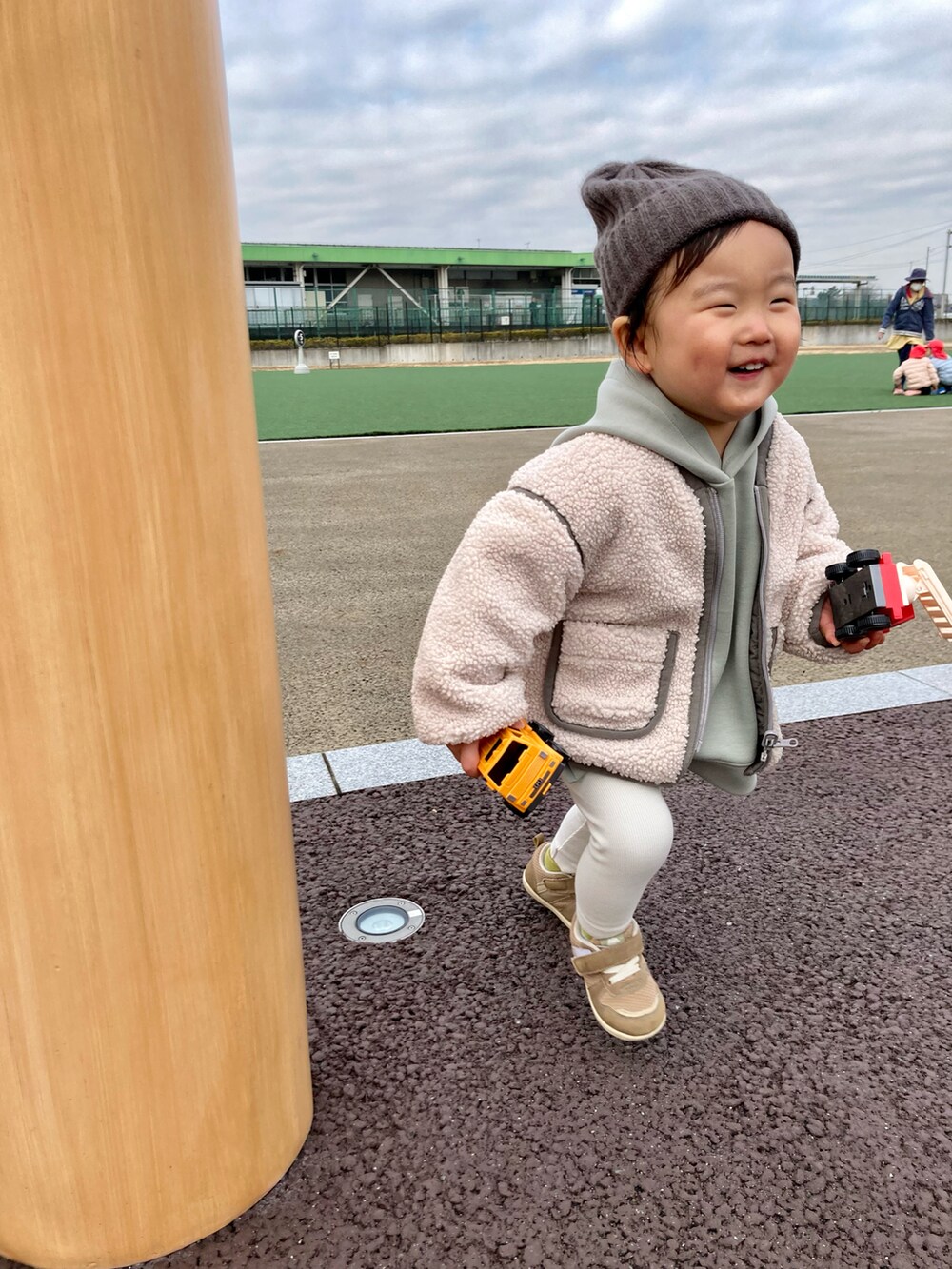 グリーン系のパーカー、ホワイト系のブルゾン、ベージュ系のスニーカーを着用したキッズの冬コーディネートの3枚目の写真