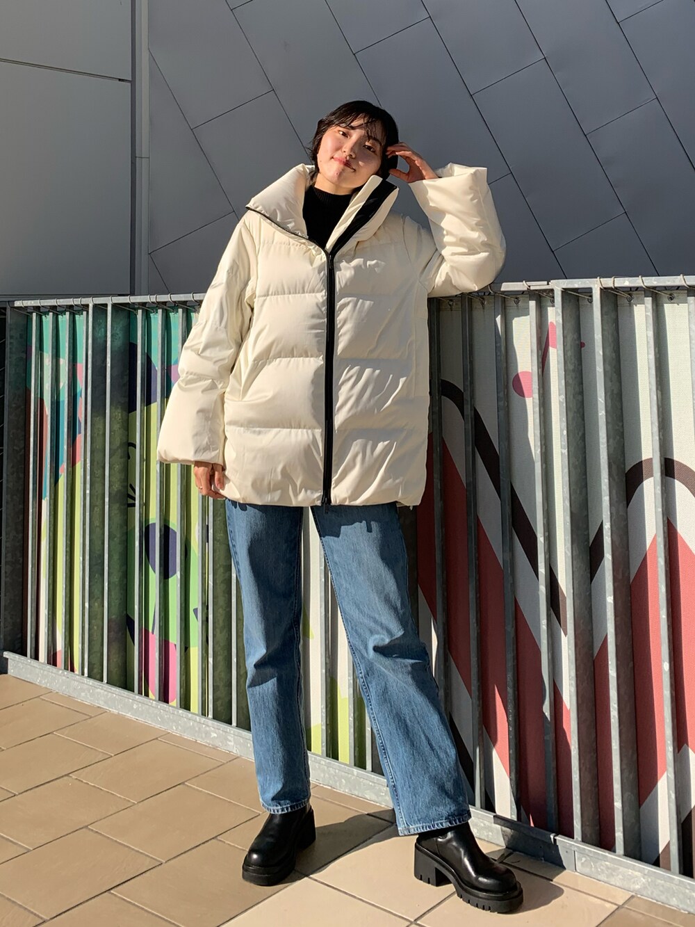 ホワイト系のジャケット/アウター、ブルー系のデニムパンツ、ブラック系のニット/セーターを着用したレディースの冬コーディネートの2枚目の写真