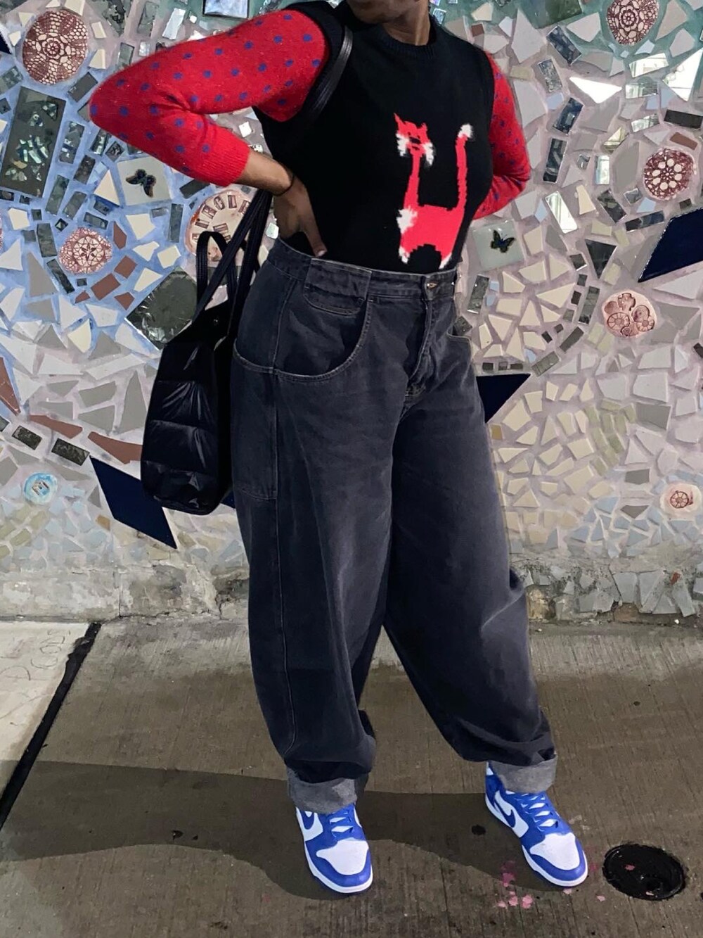 ブルー系のスニーカー、ブラック系のデニムパンツ、ブラック系のショルダーバッグを着用したレディースの冬コーディネートの2枚目の写真