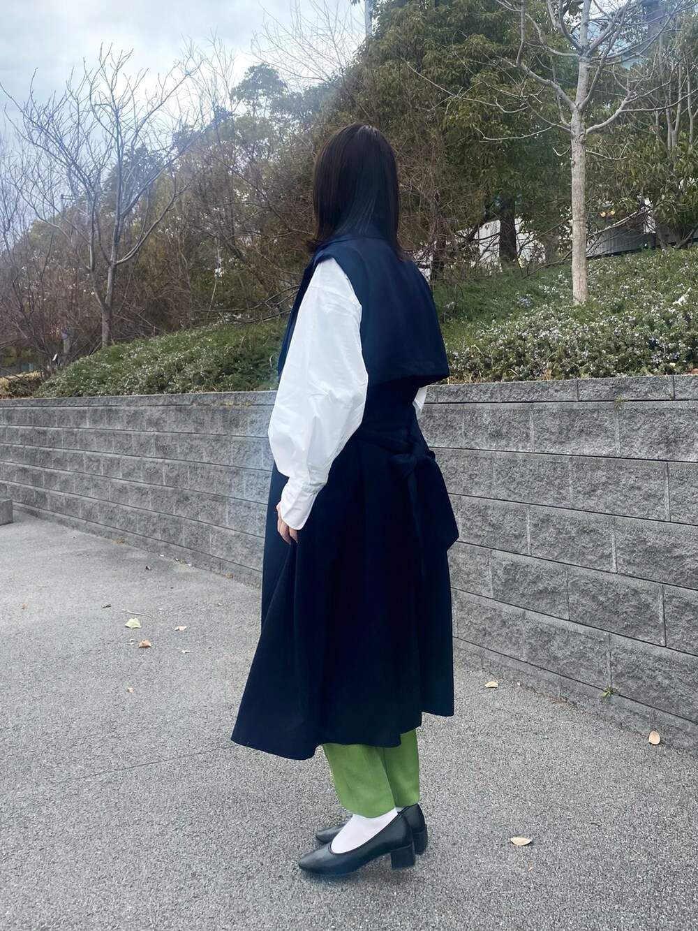 ホワイト系のシャツ/ブラウス、ブルー系のトレンチコート、ブラック系のパンプスを着用したレディースの冬コーディネートの2枚目の写真