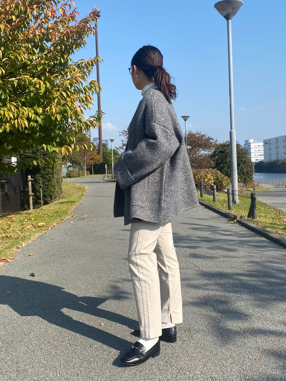 グレー系のその他アウター、ホワイト系のTシャツ/カットソー、ブルー系のニット/セーターを着用したレディースの秋コーディネートの2枚目の写真