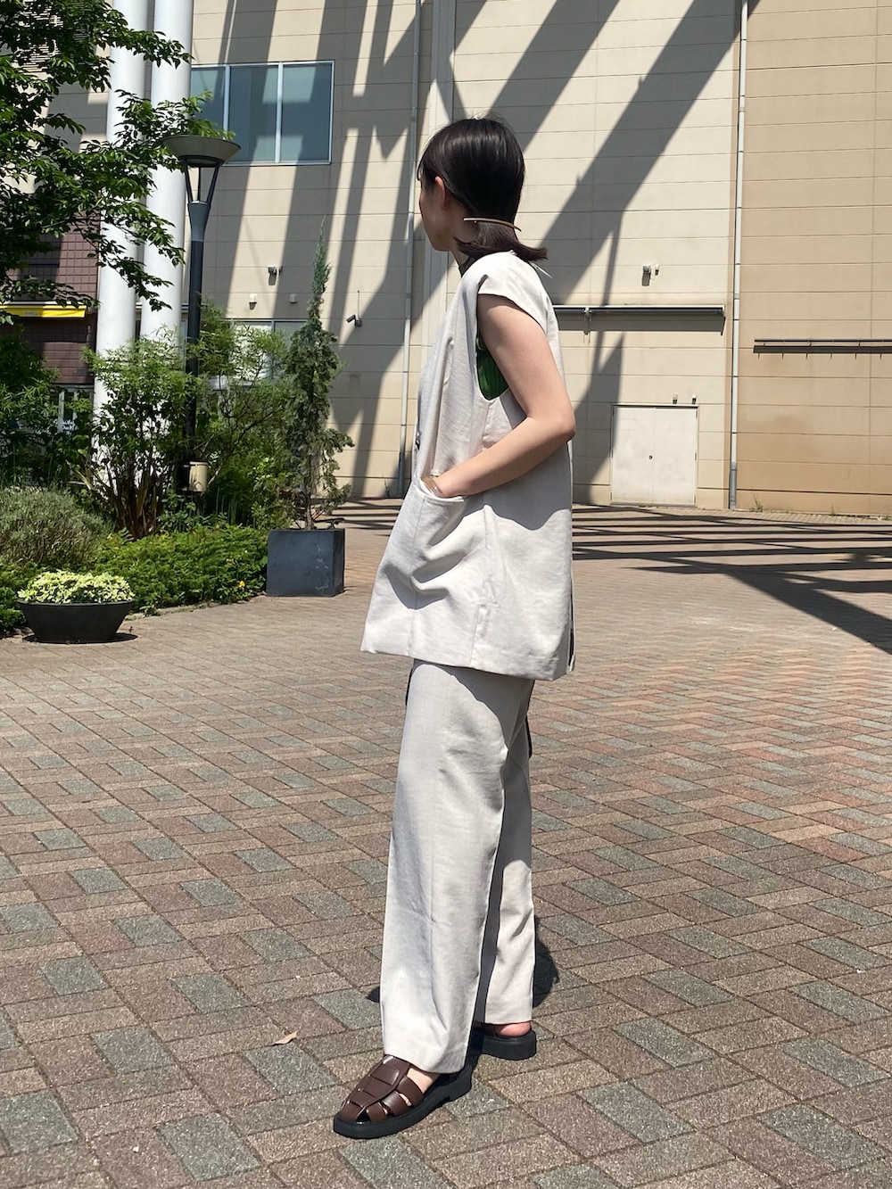 グリーン系のニット/セーター、ベージュ系のその他アウター、ベージュ系のその他パンツを着用したレディースの夏コーディネートの3枚目の写真