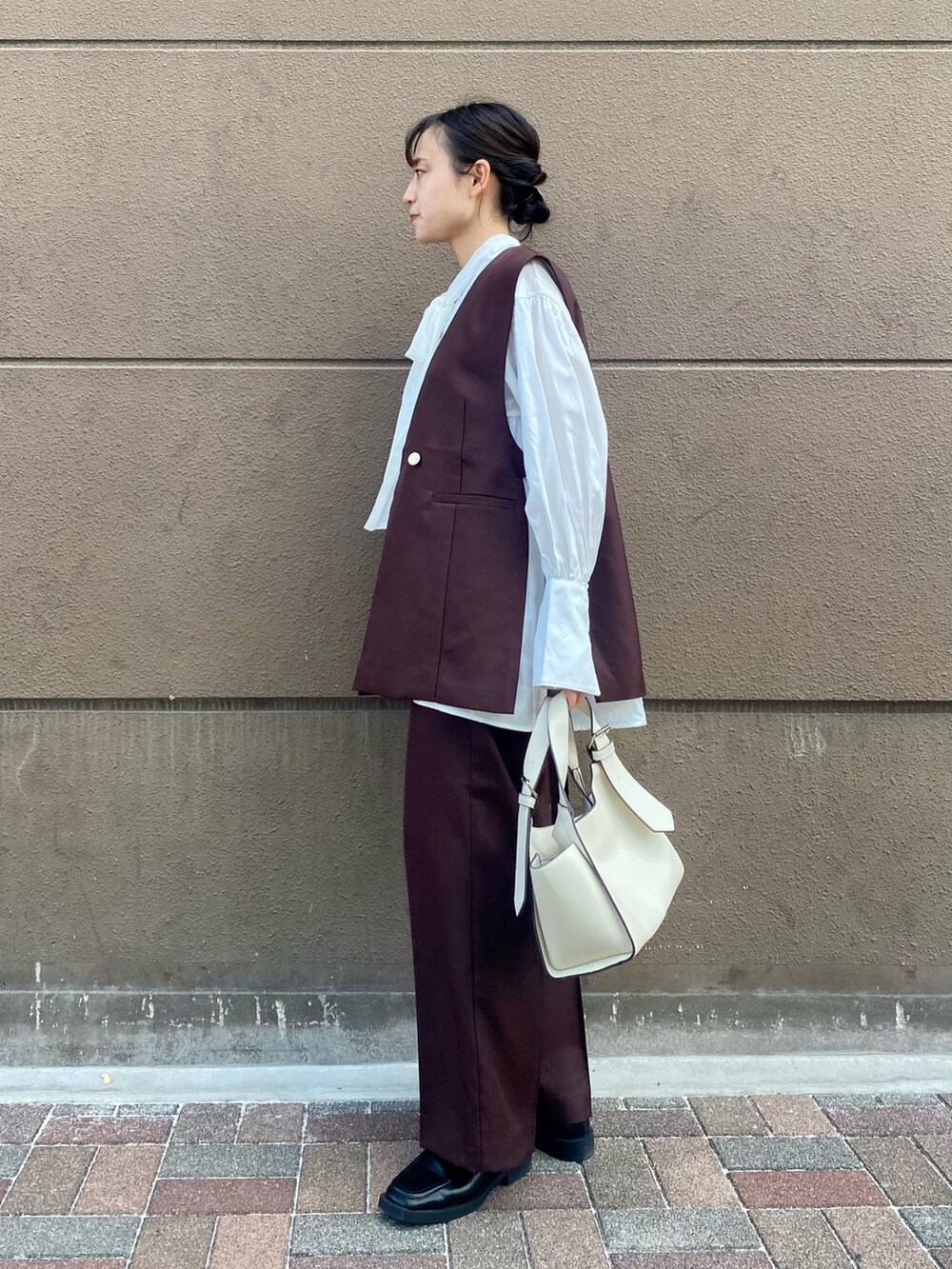 ホワイト系のシャツ/ブラウス、ブラウン系のベスト、ブラウン系のその他パンツを着用したレディースの秋コーディネートの2枚目の写真