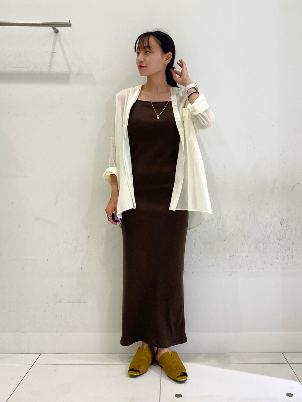 ホワイト系のシャツ/ブラウス、ブラウン系のワンピース、イエロー系のサンダルを着用したレディースの夏コーディネートの2枚目の写真