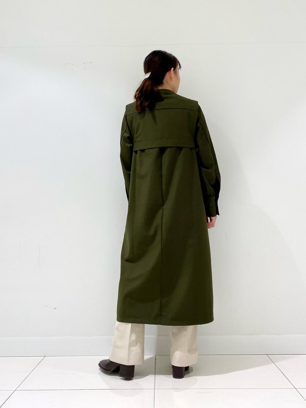 グリーン系のワンピース、ブラウン系のブーツ、ホワイト系のその他パンツを着用したレディースの冬コーディネートの3枚目の写真