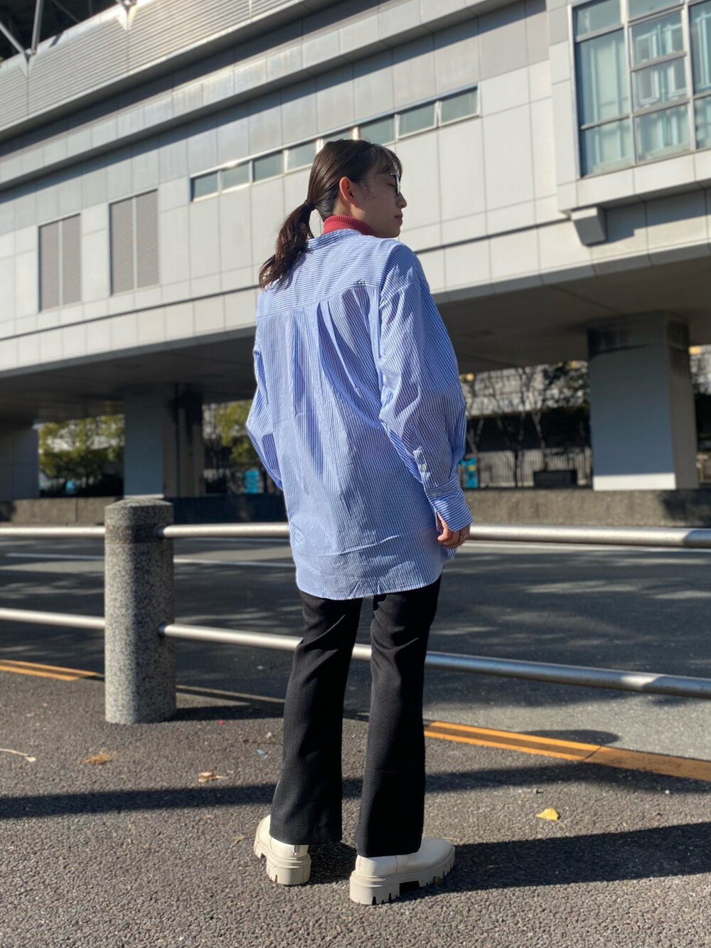 ブルー系のシャツ/ブラウス、ピンク系のニット/セーター、ホワイト系のブーツを着用したレディースの冬コーディネートの3枚目の写真