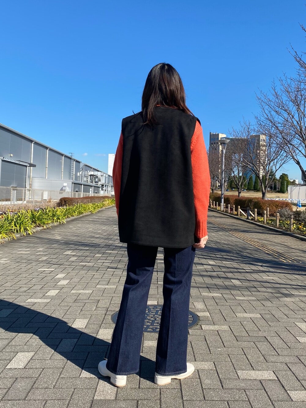 ピンク系のニット/セーター、ブラック系のベスト、ホワイト系のその他シューズを着用したレディースの冬コーディネートの3枚目の写真