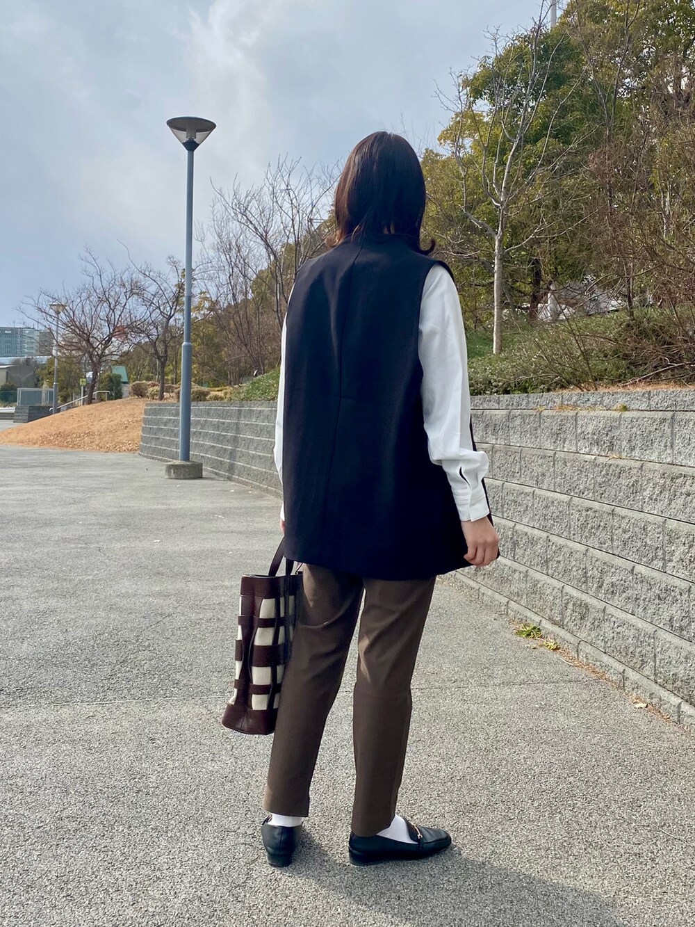 ホワイト系のシャツ/ブラウス、ブラック系のベスト、ブラウン系のその他パンツを着用したレディースの冬コーディネートの3枚目の写真