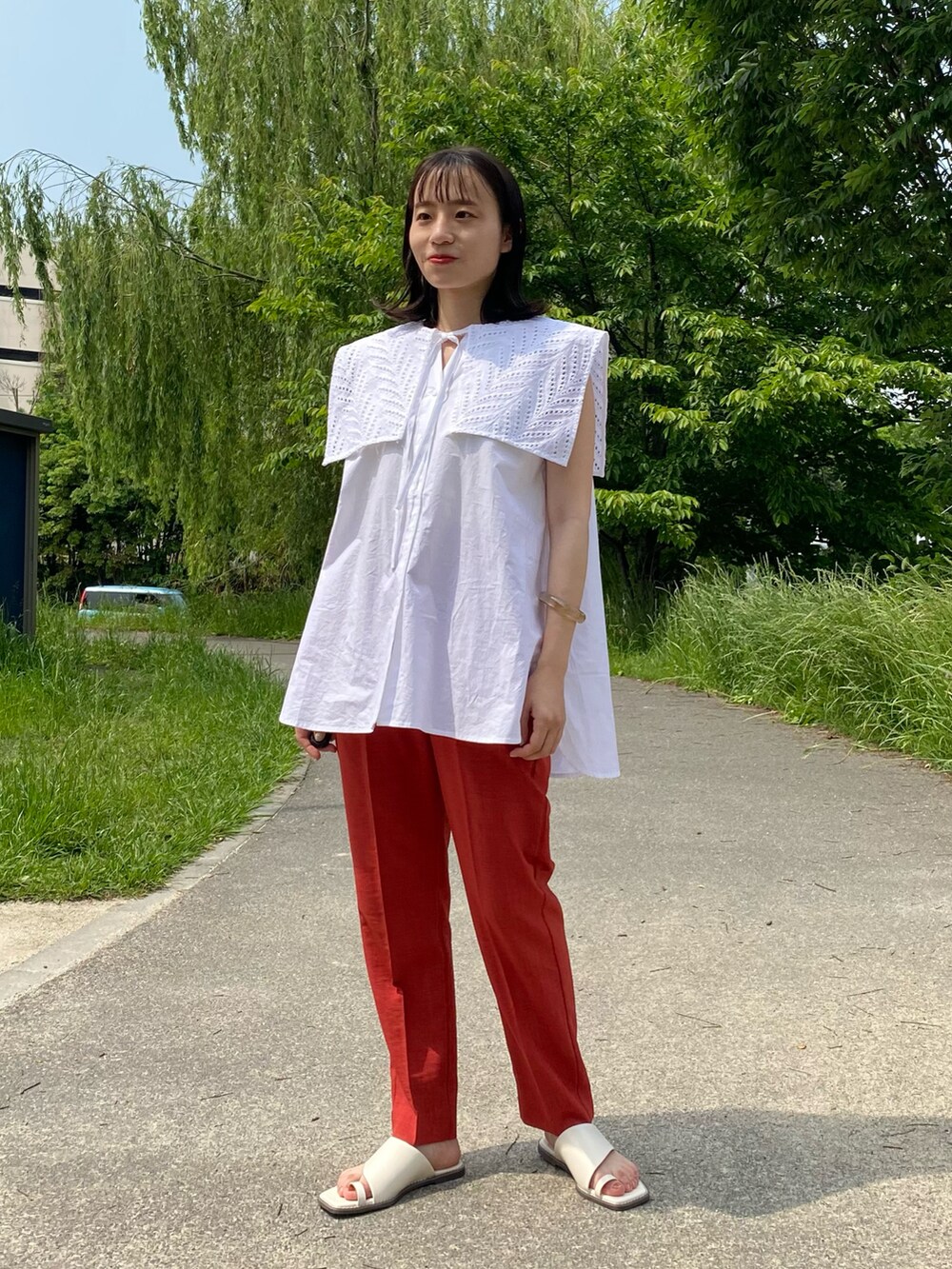 ホワイト系のシャツ/ブラウス、レッド系のその他パンツ、ホワイト系のサンダルを着用したレディースの春コーディネートの2枚目の写真