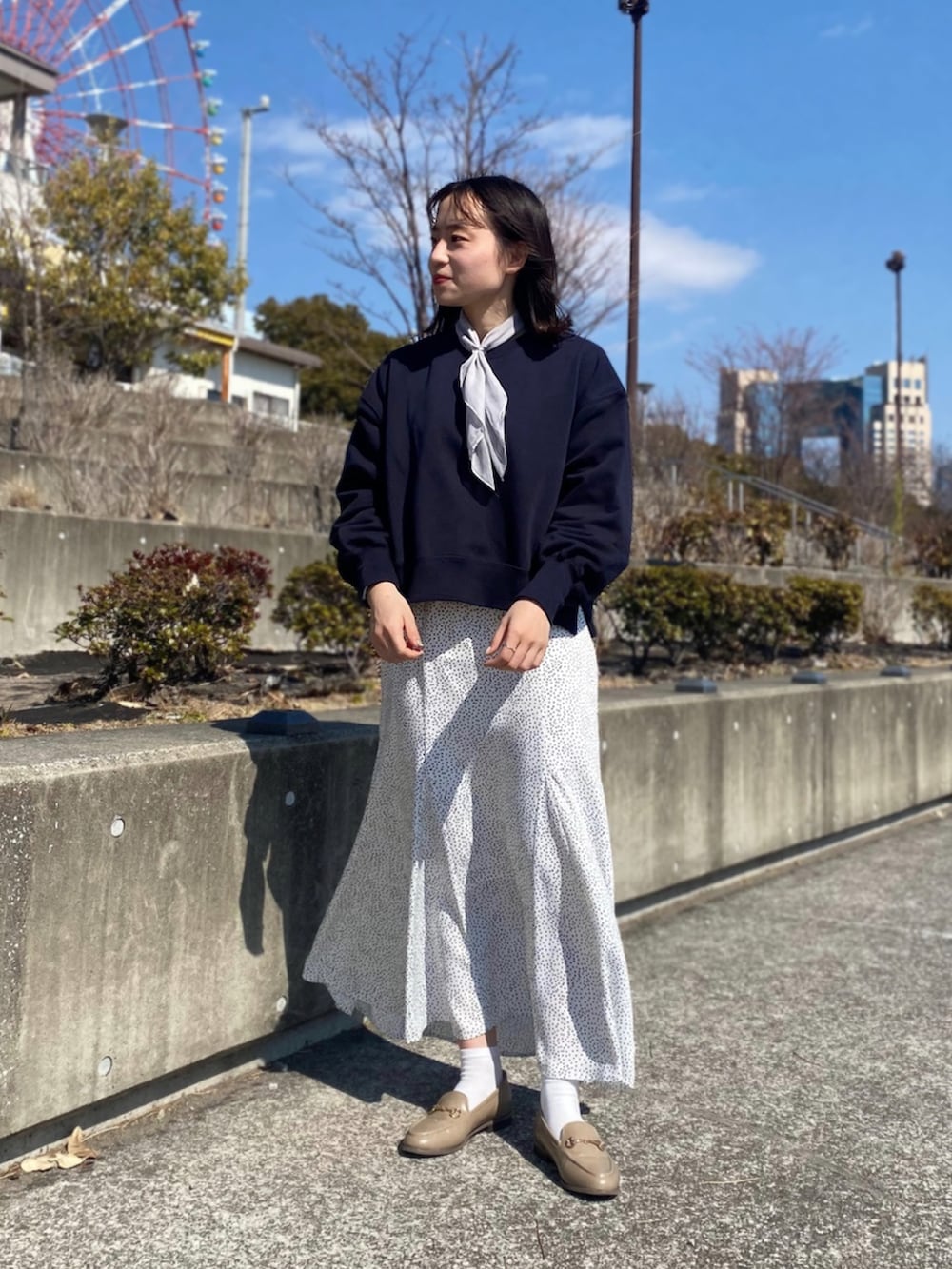 ブルー系のスウェット、ホワイト系のスカート、ベージュ系のその他シューズを着用したレディースの春コーディネートの2枚目の写真