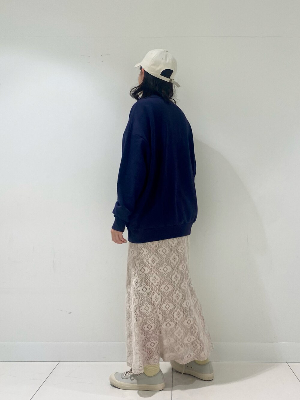 ブルー系のスウェット、ホワイト系のスカート、ホワイト系のキャップを着用したレディースの冬コーディネートの3枚目の写真