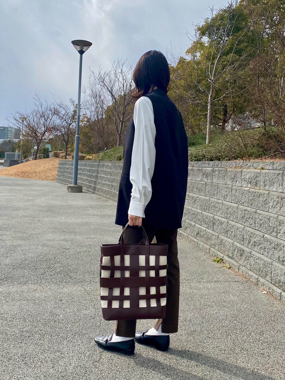 ホワイト系のシャツ/ブラウス、ブラック系のベスト、ブラウン系のその他パンツを着用したレディースの冬コーディネートの4枚目の写真