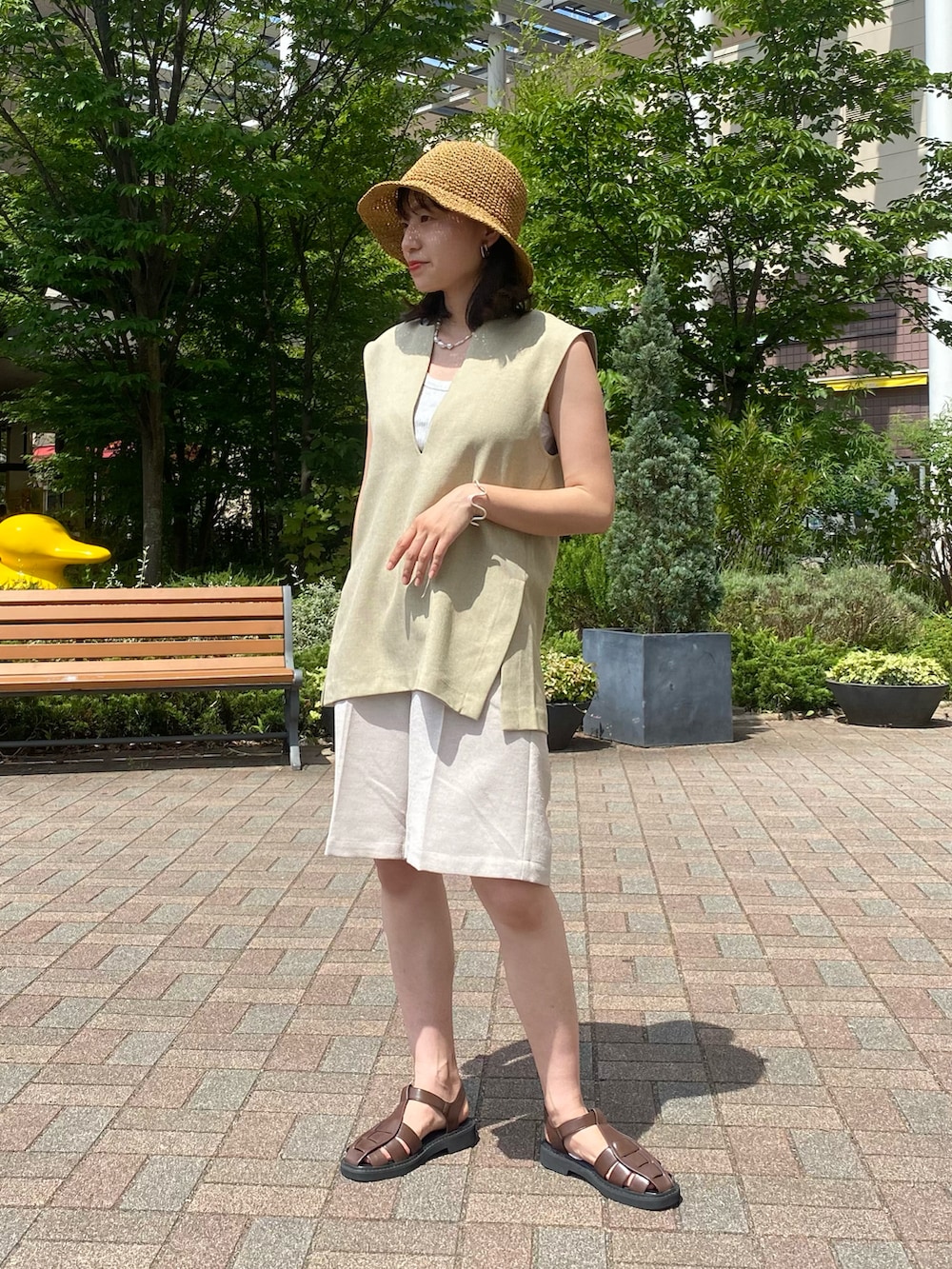 ベージュ系のその他パンツ、ブラウン系のサンダル、ベージュ系のベストを着用したレディースの夏コーディネートの2枚目の写真