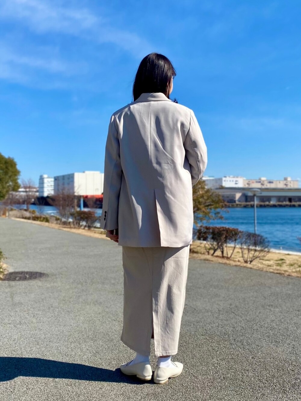 ブラウン系のTシャツ/カットソー、ベージュ系のテーラードジャケット、ベージュ系のスカートを着用したレディースの冬コーディネートの2枚目の写真