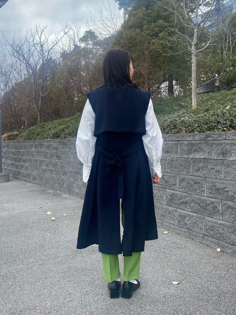 ホワイト系のシャツ/ブラウス、ブルー系のトレンチコート、ブラック系のパンプスを着用したレディースの冬コーディネートの3枚目の写真