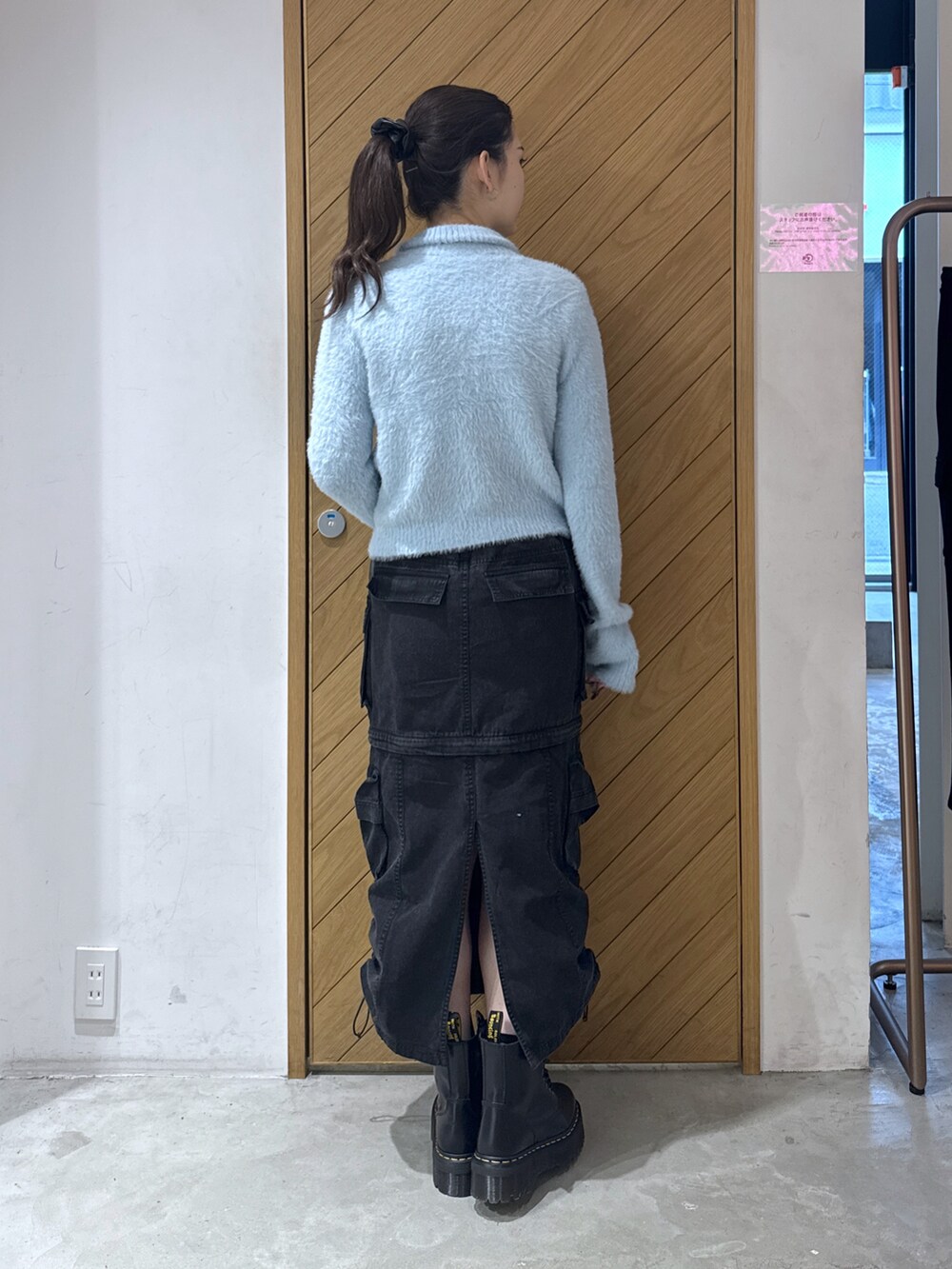 ブルー系のニット/セーター、ブラック系のスカートを着用したレディースの秋コーディネートの2枚目の写真