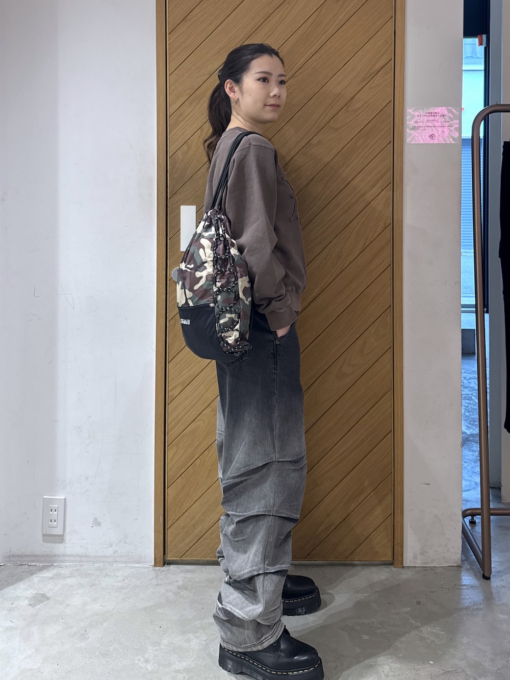 ブラウン系のスウェット、ブルー系のデニムパンツ、その他のバックパック/リュックを着用したレディースの秋コーディネートの2枚目の写真