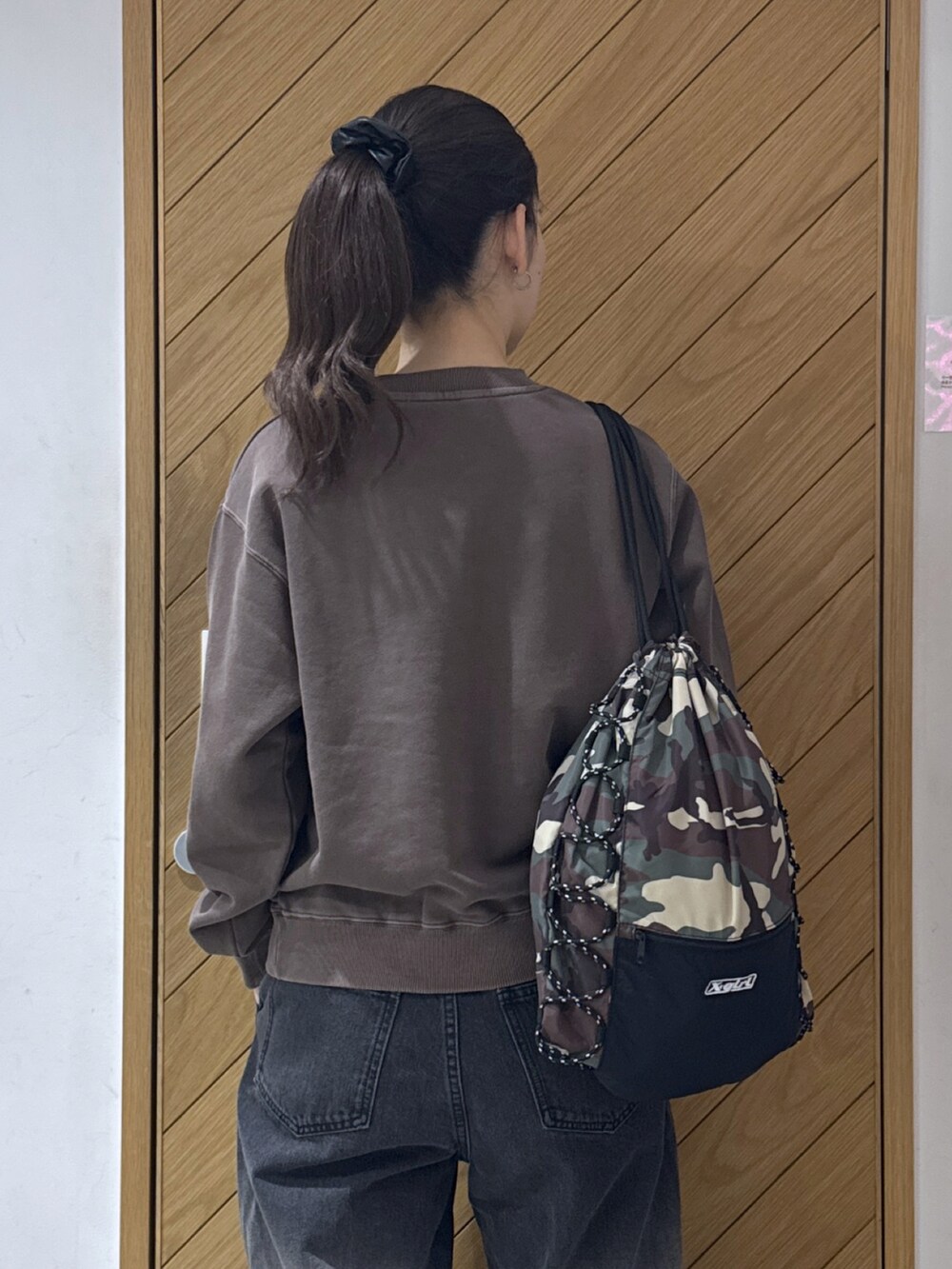 ブラウン系のスウェット、ブルー系のデニムパンツ、その他のバックパック/リュックを着用したレディースの秋コーディネートの3枚目の写真