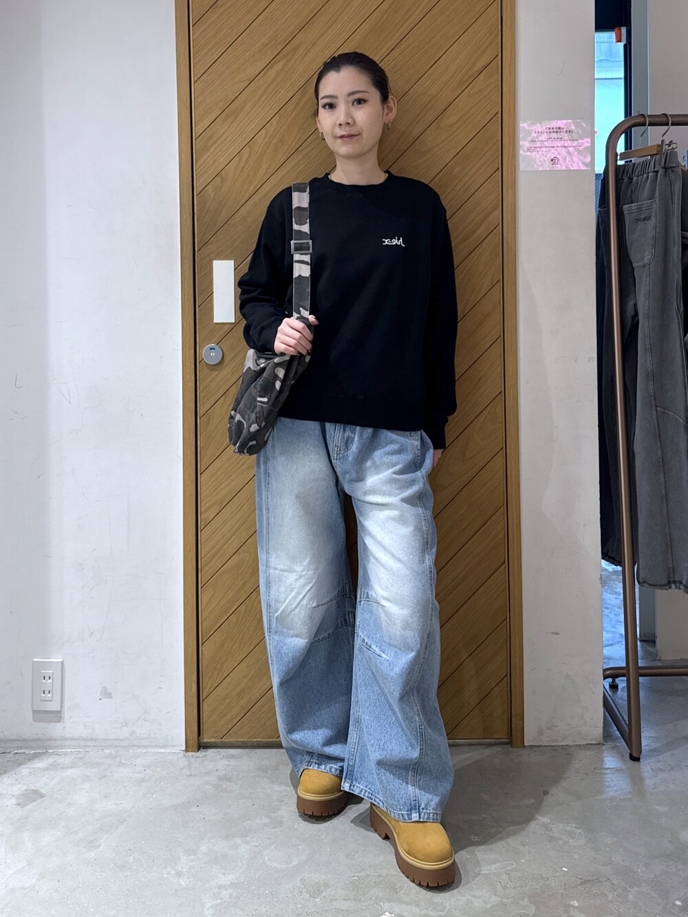 ブラック系のスウェット、その他のショルダーバッグ、ブラック系のデニムパンツを着用したレディースの秋コーディネートの2枚目の写真