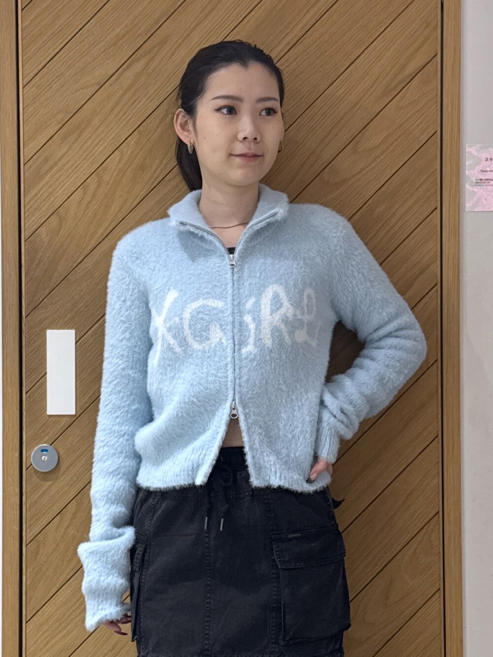 ブルー系のニット/セーター、ブラック系のスカートを着用したレディースの秋コーディネートの3枚目の写真