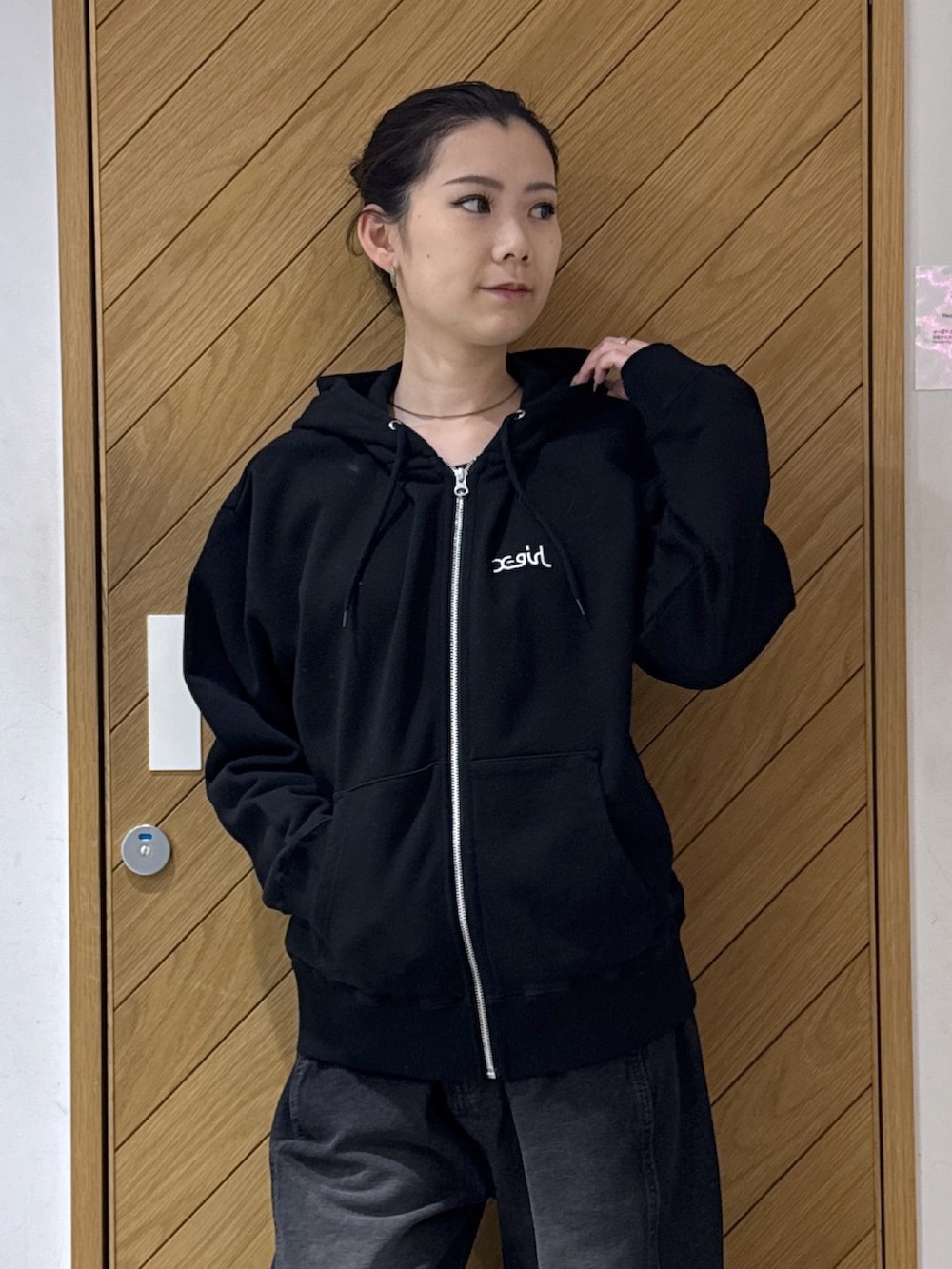 ブラック系のパーカー、ブラック系のデニムパンツを着用したレディースの秋コーディネートの5枚目の写真