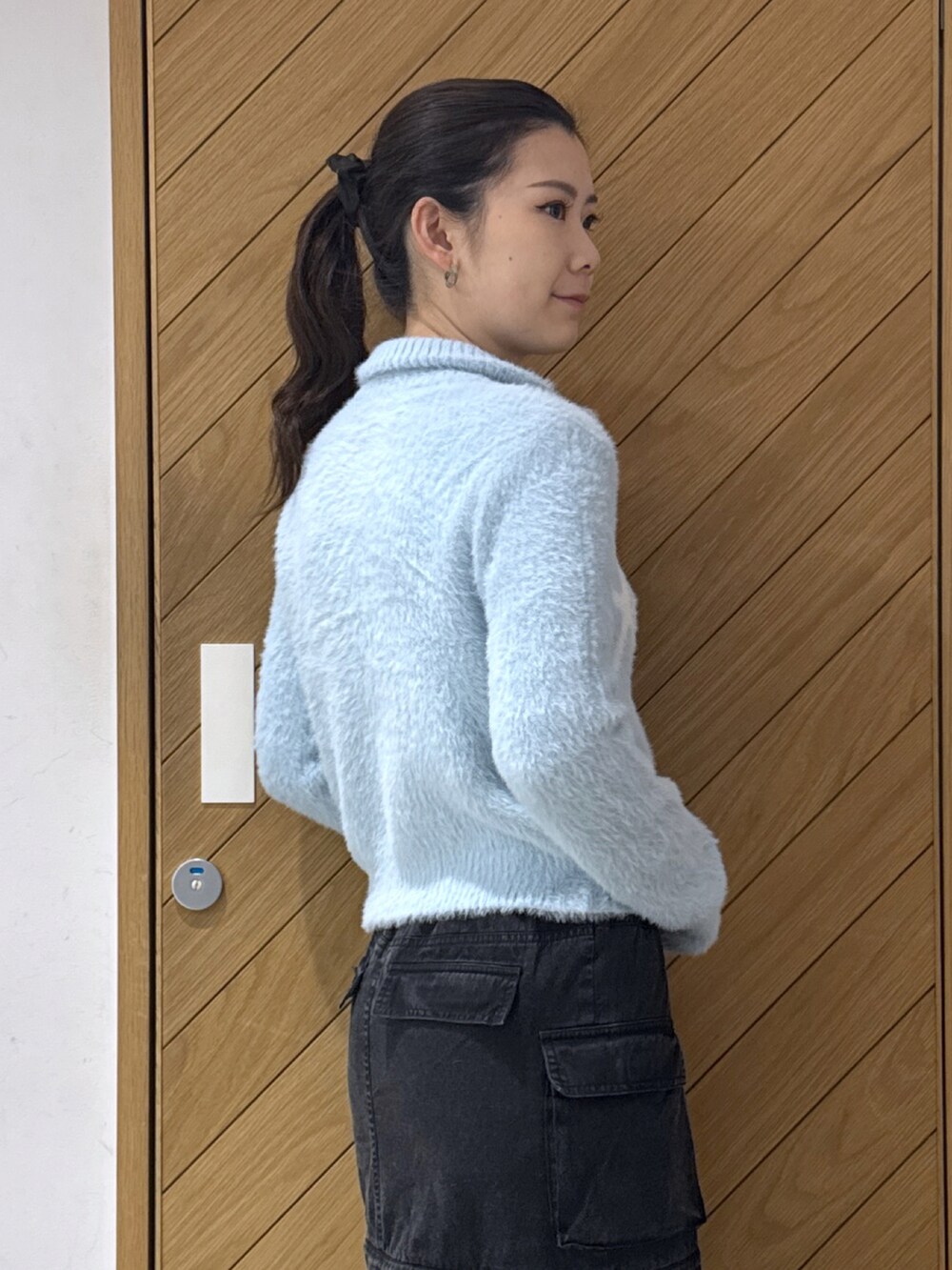 ブルー系のニット/セーター、ブラック系のスカートを着用したレディースの秋コーディネートの4枚目の写真