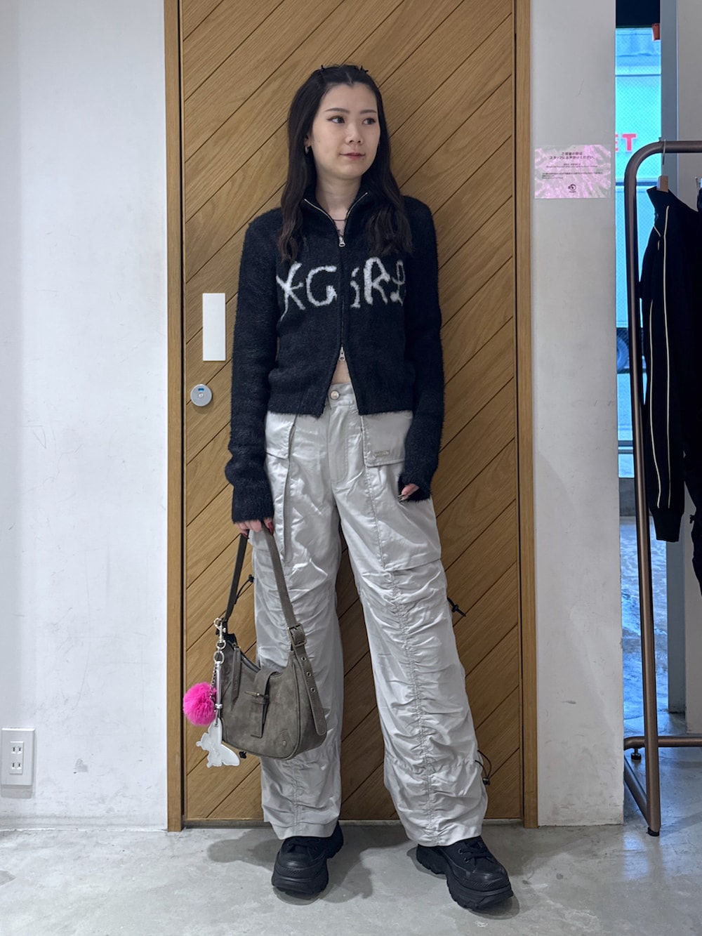 ブラック系のニット/セーター、グレー系のその他パンツ、ブラウン系のハンドバッグを着用したレディースの秋コーディネートの2枚目の写真