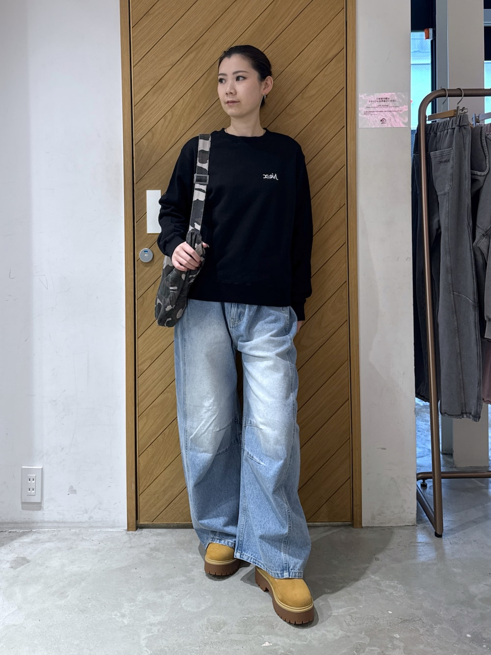 ブラック系のスウェット、その他のショルダーバッグ、ブラック系のデニムパンツを着用したレディースの秋コーディネートの3枚目の写真