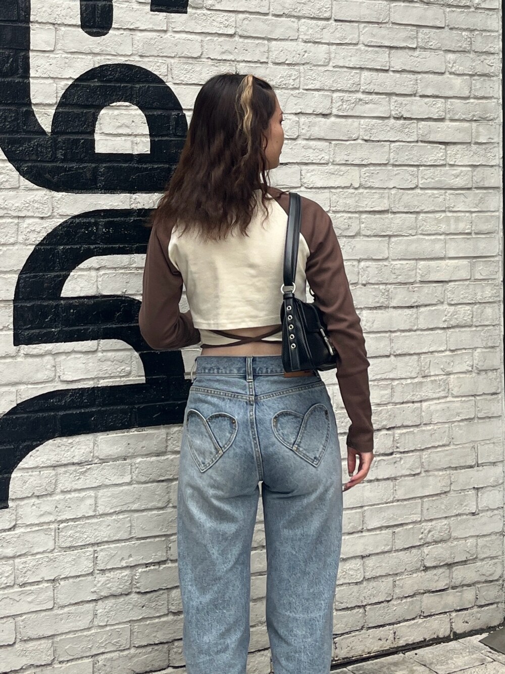 ホワイト系のTシャツ/カットソー、ブラック系のショルダーバッグ、ブルー系のデニムパンツを着用したレディースの夏コーディネートの4枚目の写真