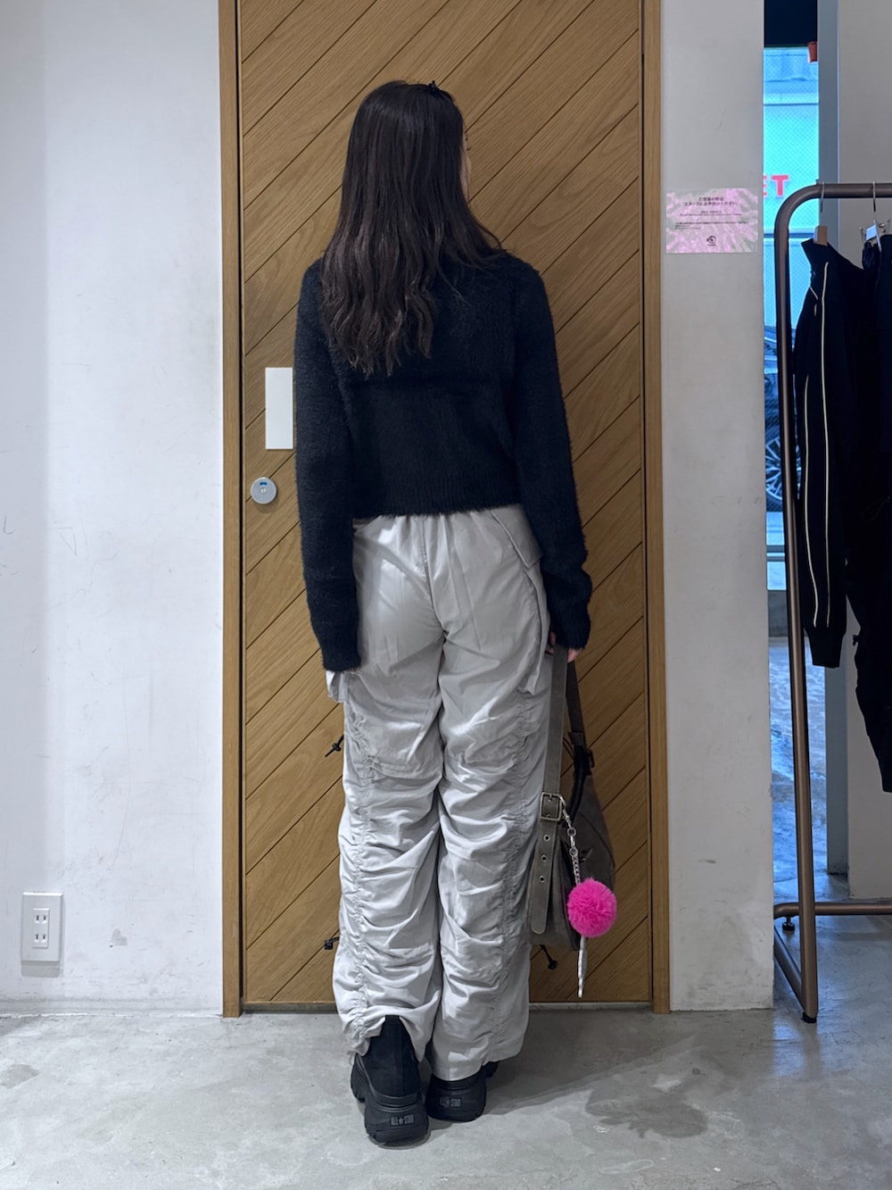 ブラック系のニット/セーター、グレー系のその他パンツ、ブラウン系のハンドバッグを着用したレディースの秋コーディネートの4枚目の写真
