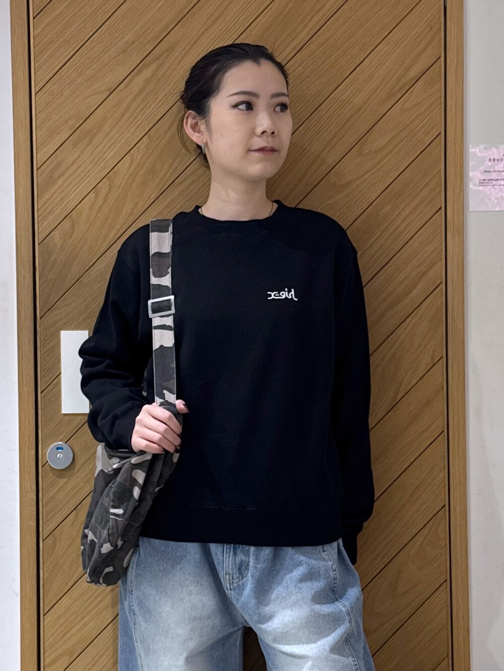 ブラック系のスウェット、その他のショルダーバッグ、ブラック系のデニムパンツを着用したレディースの秋コーディネートの5枚目の写真