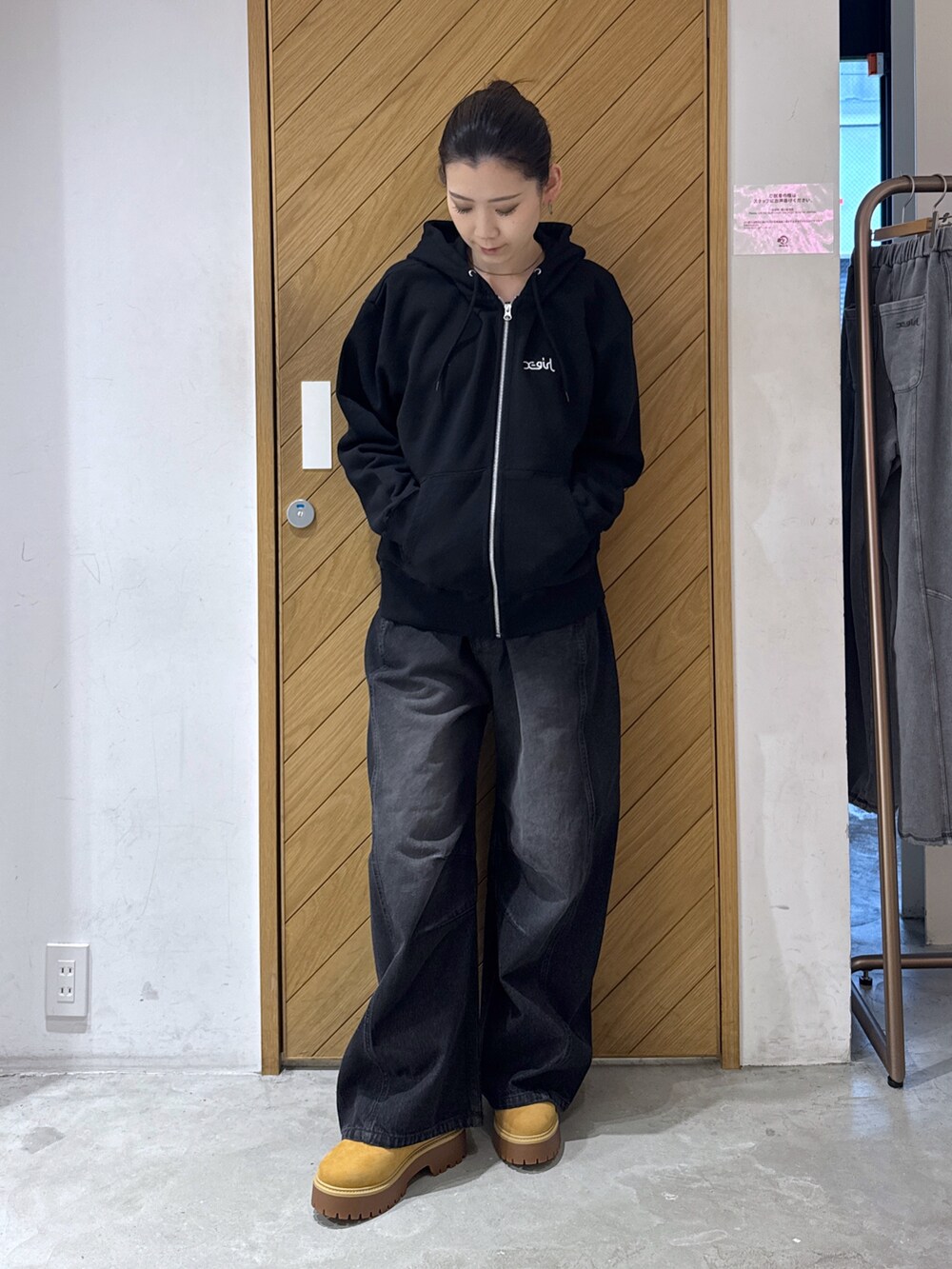 ブラック系のパーカー、ブラック系のデニムパンツを着用したレディースの秋コーディネートの3枚目の写真
