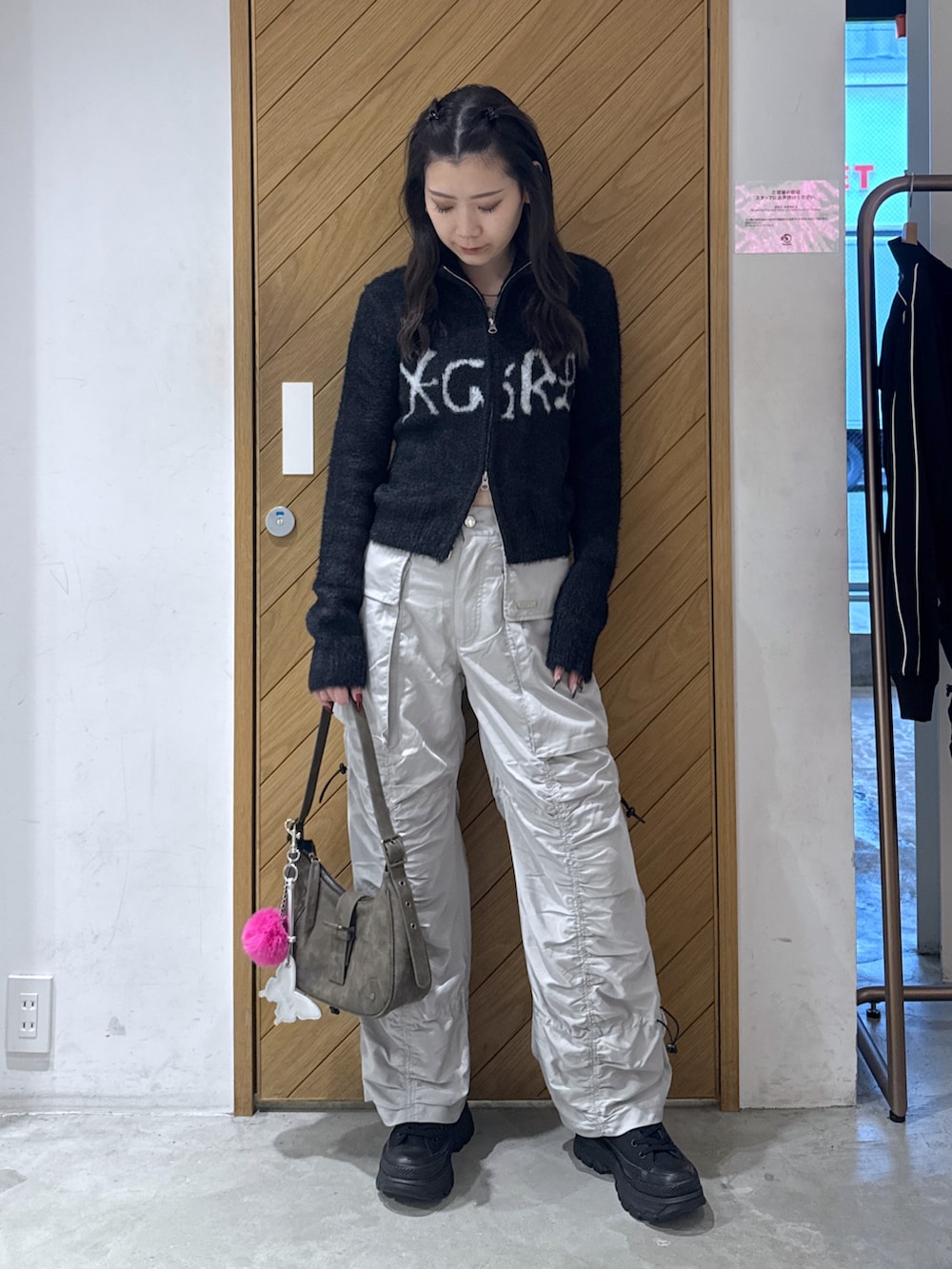 ブラック系のニット/セーター、グレー系のその他パンツ、ブラウン系のハンドバッグを着用したレディースの秋コーディネートの3枚目の写真