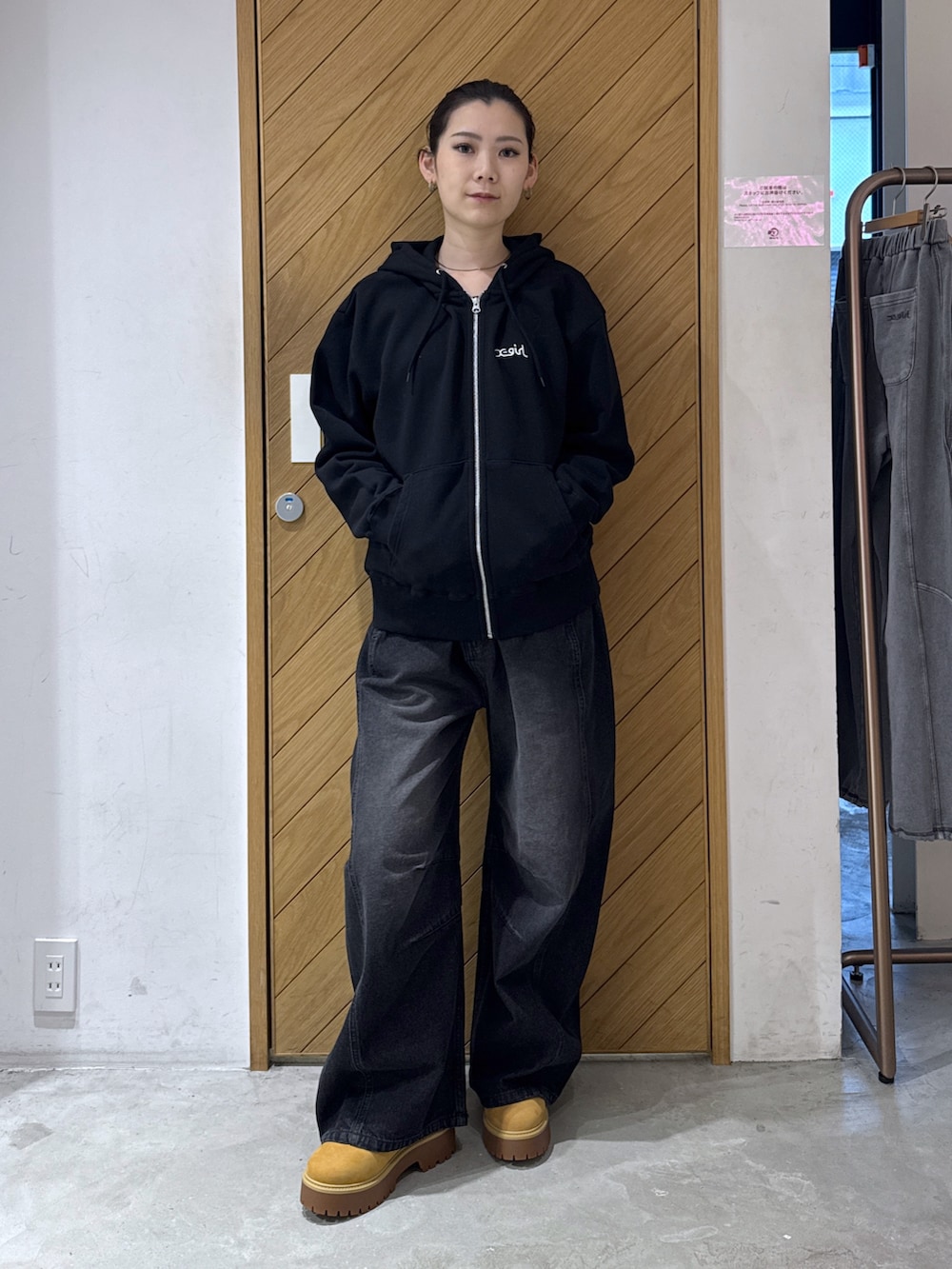 ブラック系のパーカー、ブラック系のデニムパンツを着用したレディースの秋コーディネートの2枚目の写真