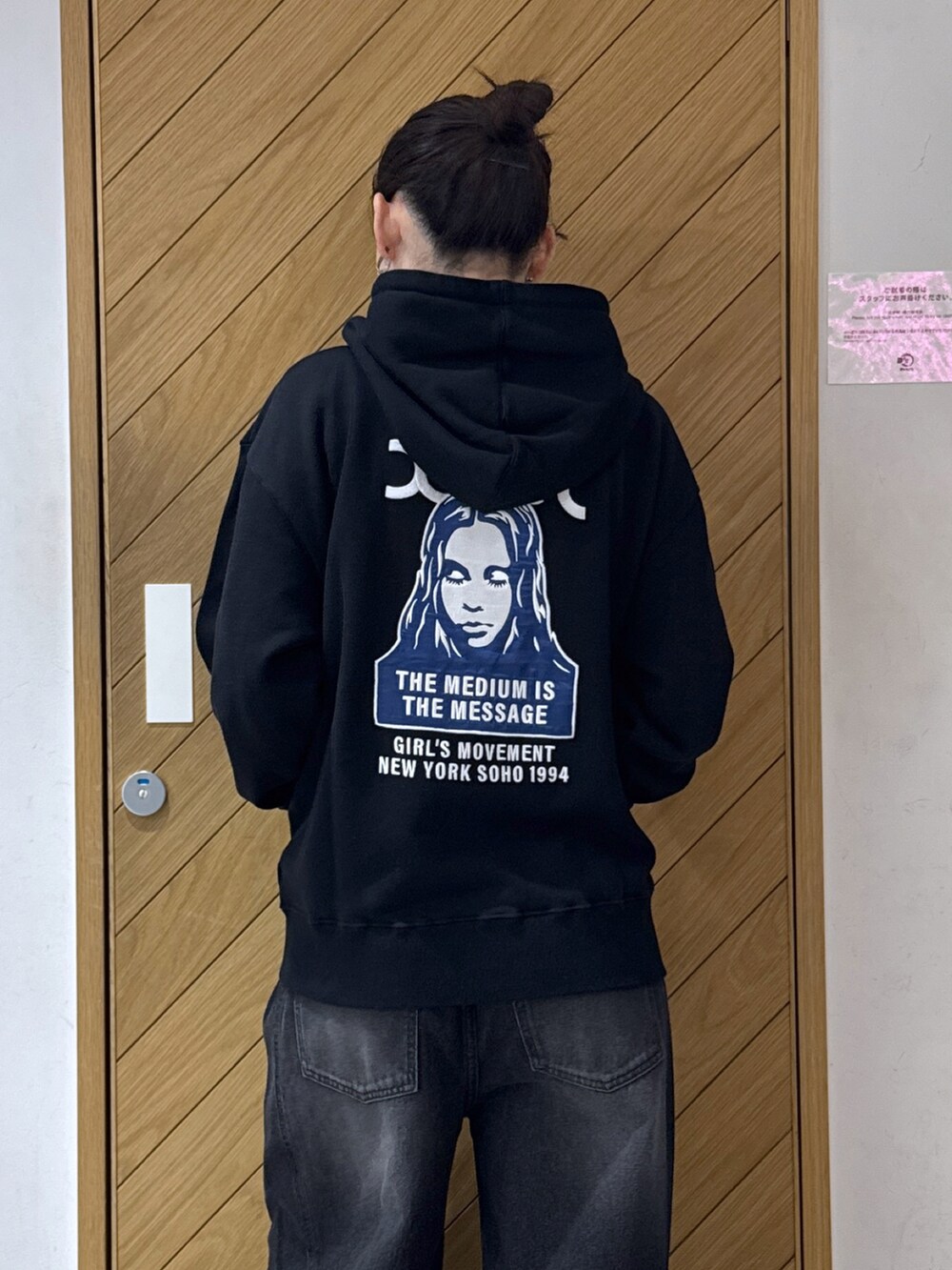 ブラック系のパーカー、ブラック系のデニムパンツを着用したレディースの秋コーディネートの4枚目の写真