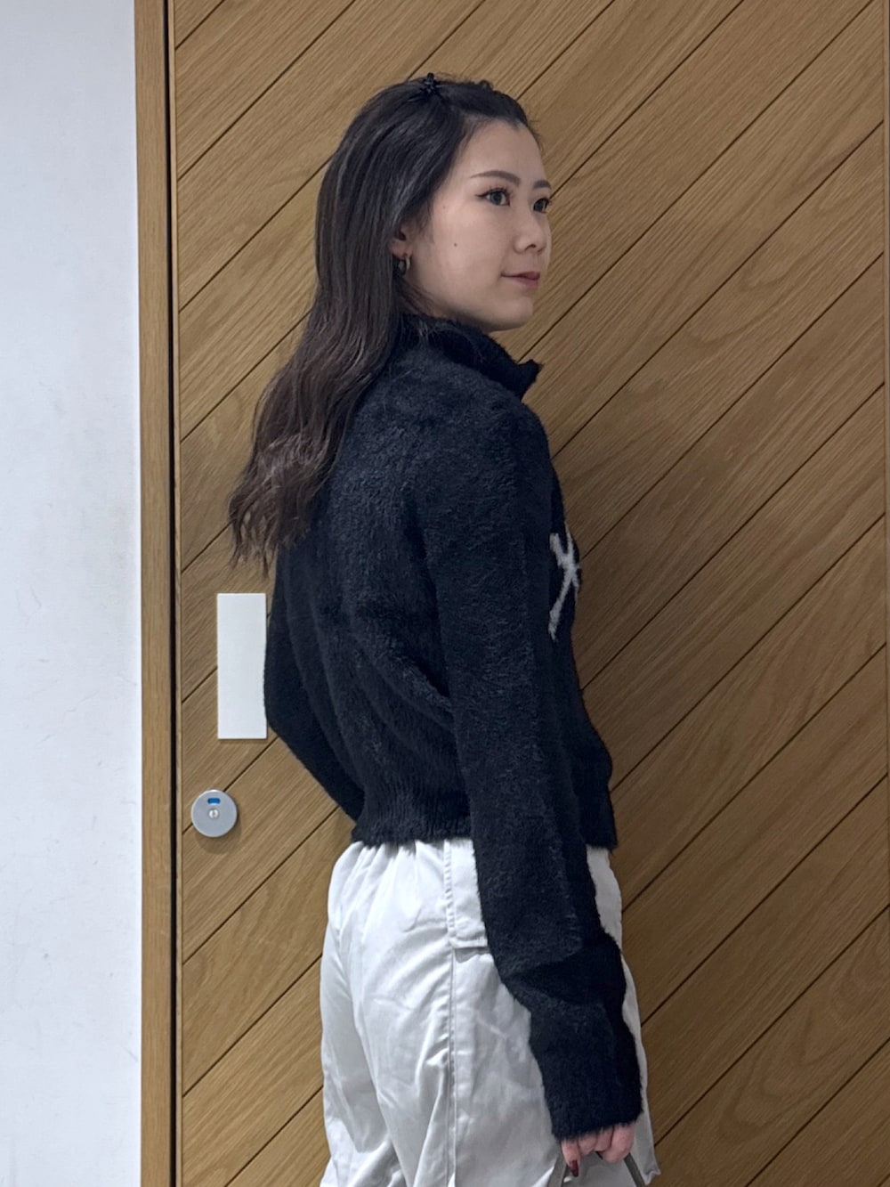 ブラック系のニット/セーター、グレー系のその他パンツ、ブラウン系のハンドバッグを着用したレディースの秋コーディネートの5枚目の写真