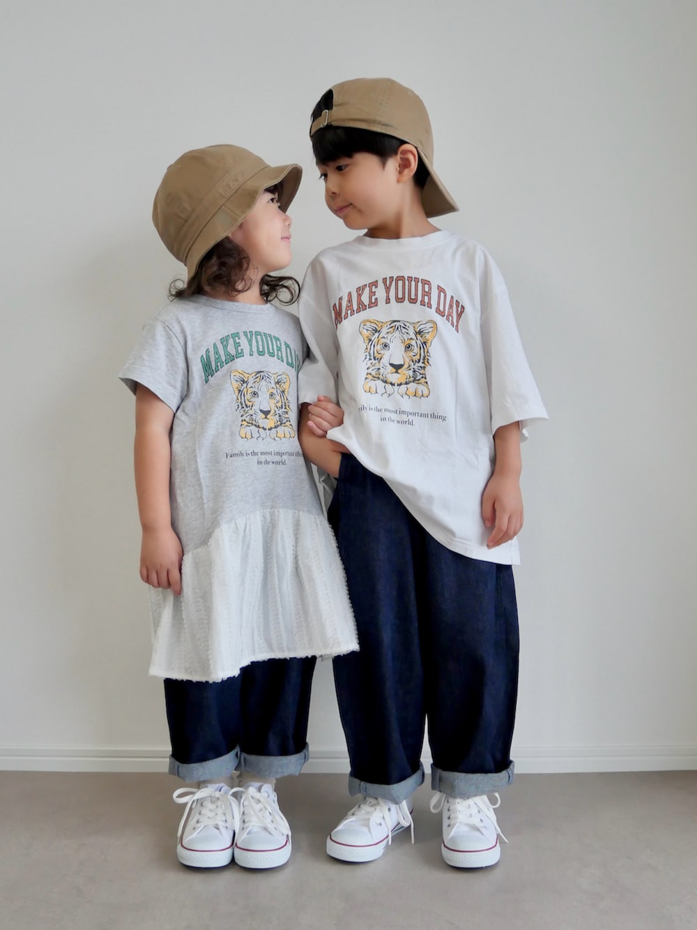 ホワイト系のTシャツ/カットソー、グレー系のワンピース、ブルー系のデニムパンツを着用したキッズの秋コーディネートの2枚目の写真
