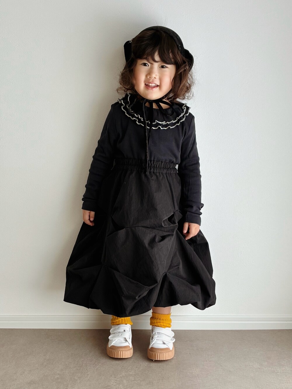 ベージュ系のスリッポン、ブラック系のスウェット、ブラック系のデニムパンツを着用したキッズの秋コーディネートの3枚目の写真