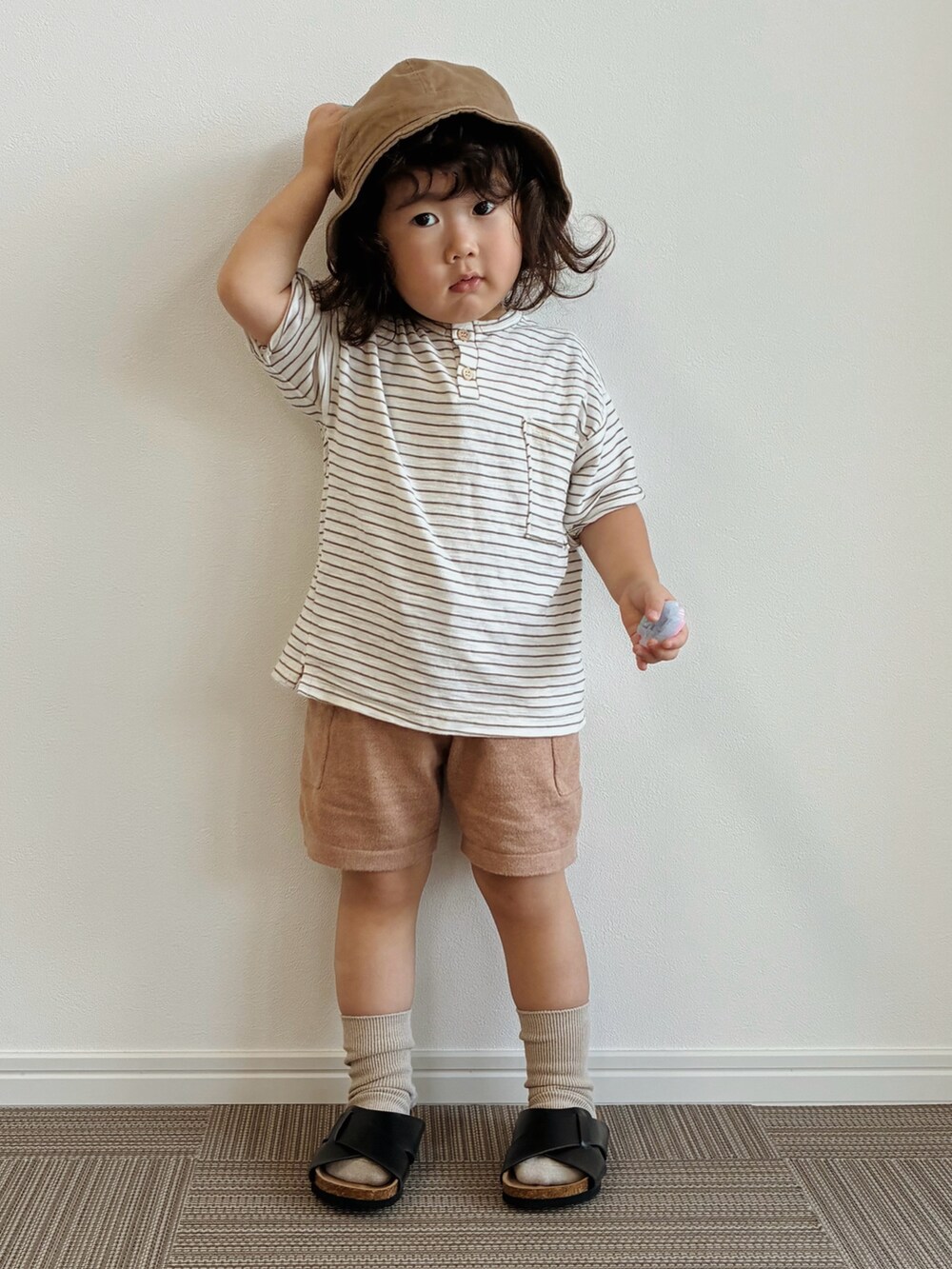 ホワイト系のTシャツ/カットソー、ブラウン系のパンツ、ブラック系のサンダルを着用したキッズの夏コーディネートの3枚目の写真