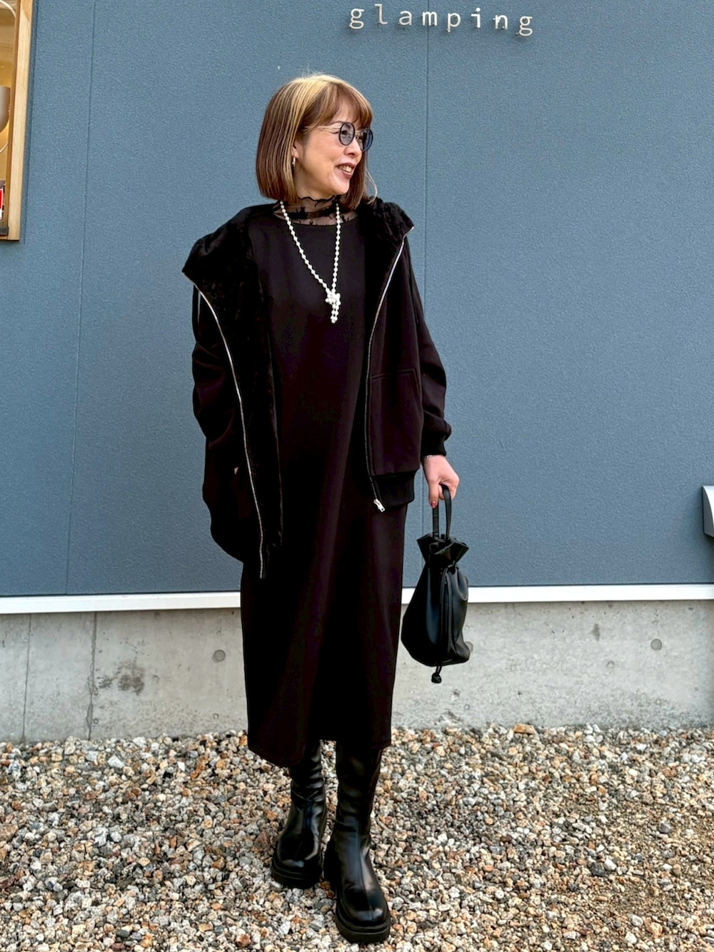 ブラック系のバッグ、ブラック系のブーツ、ブラック系のワンピース/ドレスを着用したレディースの冬コーディネートの2枚目の写真