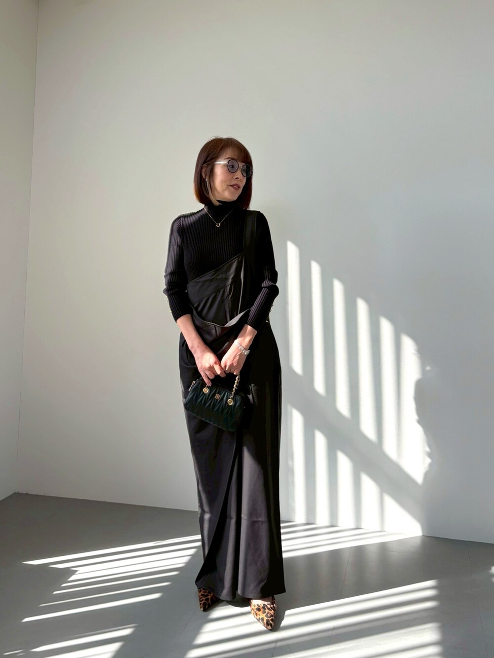 ブラック系のオールインワン・サロペット、その他のパンプス、ブラック系のバッグを着用したレディースの秋コーディネートの2枚目の写真