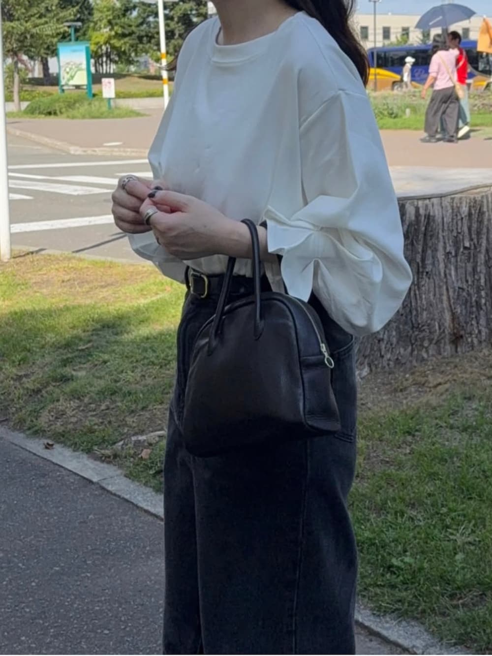 ホワイト系のTシャツ/カットソー、ブラック系のスカート、ブラック系のショルダーバッグを着用したレディースの秋コーディネートの2枚目の写真