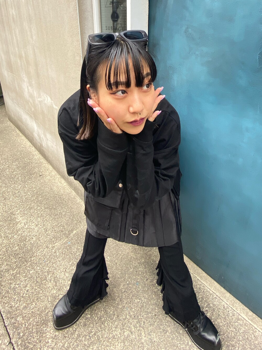 ブラック系のスカート、ブラック系のTシャツ/カットソー、ブラック系のブーツを着用したレディースの春コーディネートの2枚目の写真