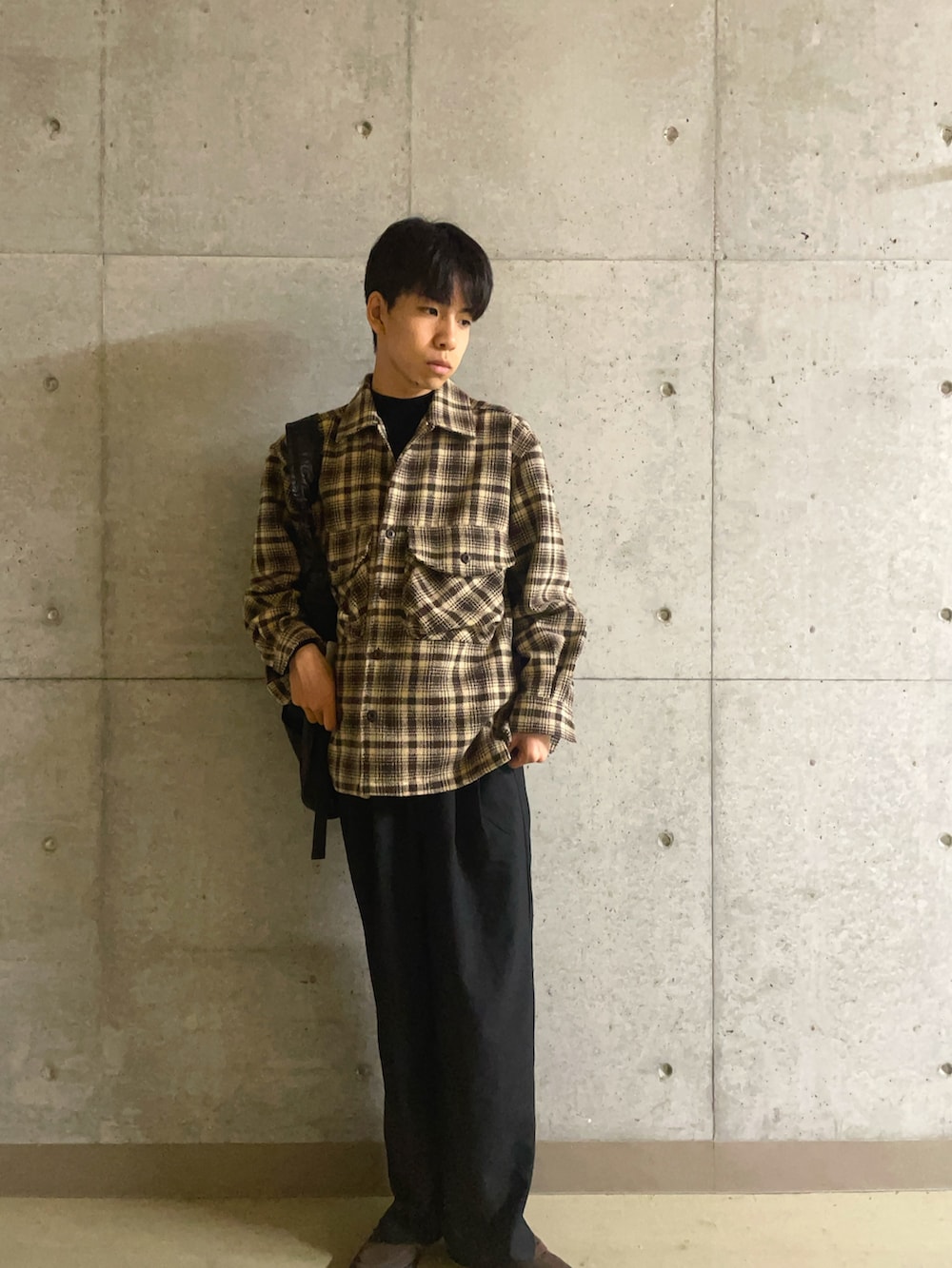 ブラウン系のその他アウター、ブラック系のショルダーバッグ、ブラック系のその他パンツを着用したメンズの秋コーディネートの2枚目の写真