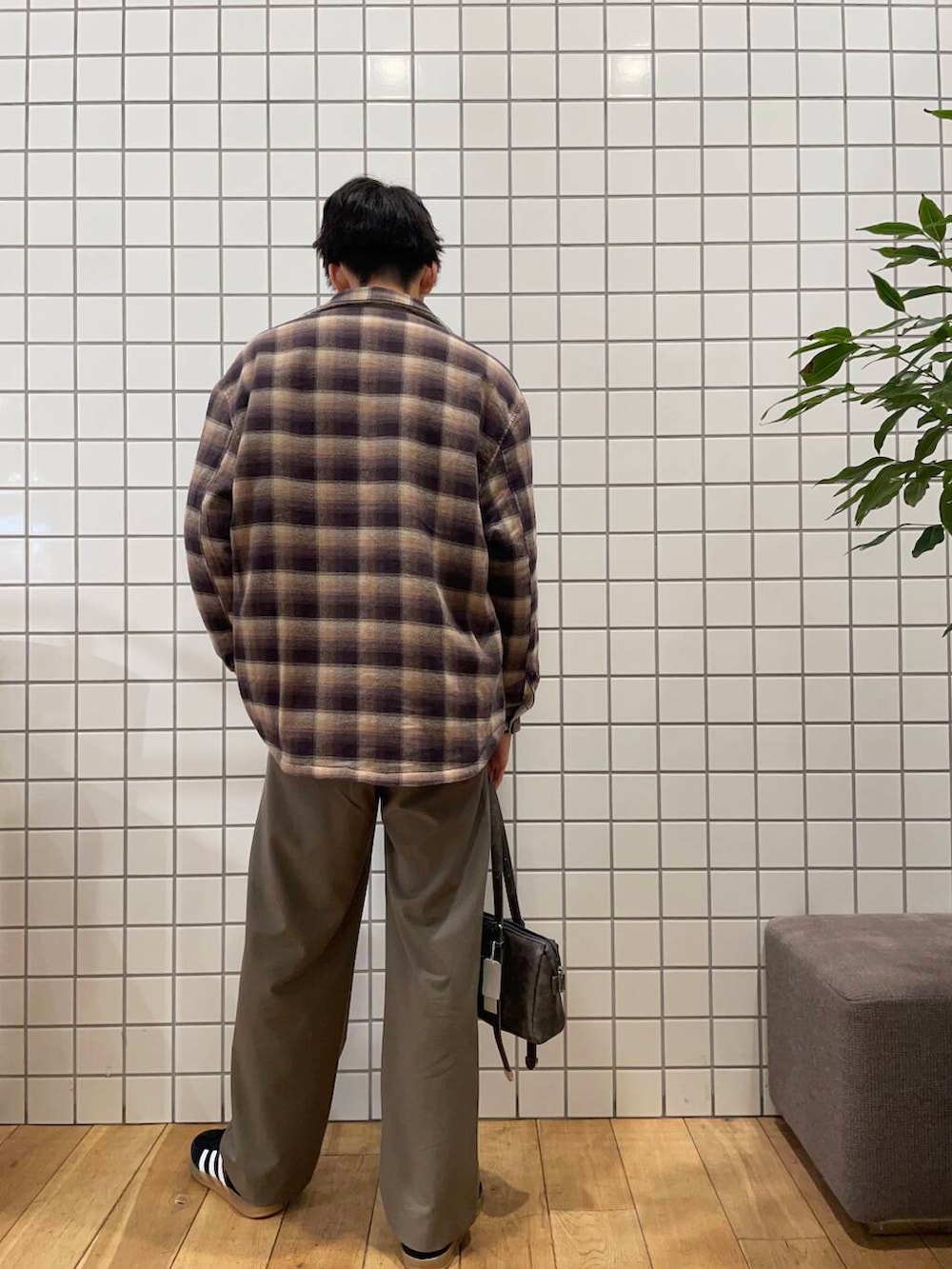 グレー系のボストンバッグ、ブラウン系のその他アウター、グレー系のスウェットを着用したメンズの冬コーディネートの5枚目の写真