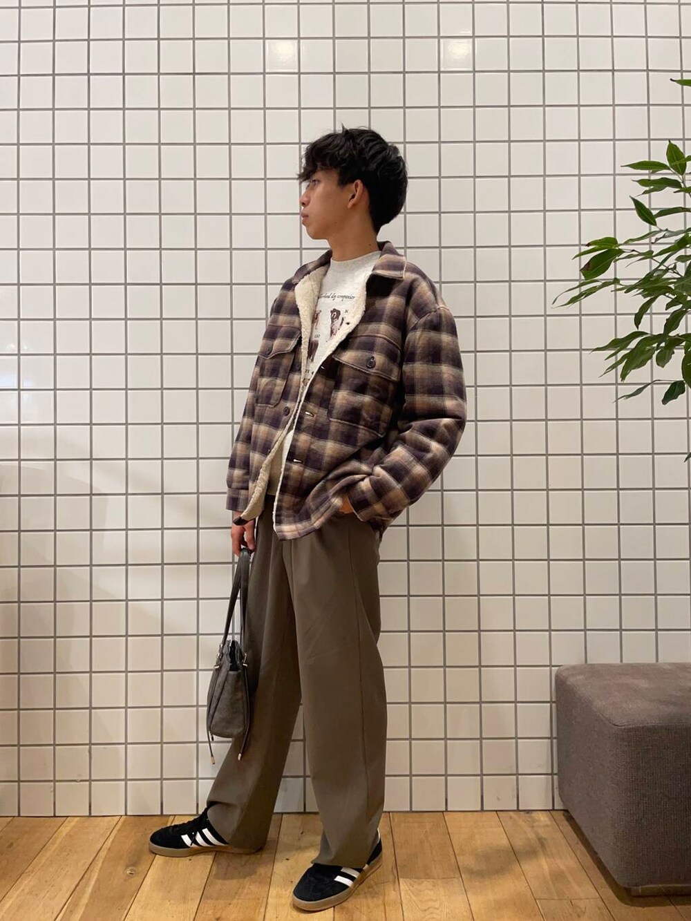 グレー系のボストンバッグ、ブラウン系のその他アウター、グレー系のスウェットを着用したメンズの冬コーディネートの3枚目の写真