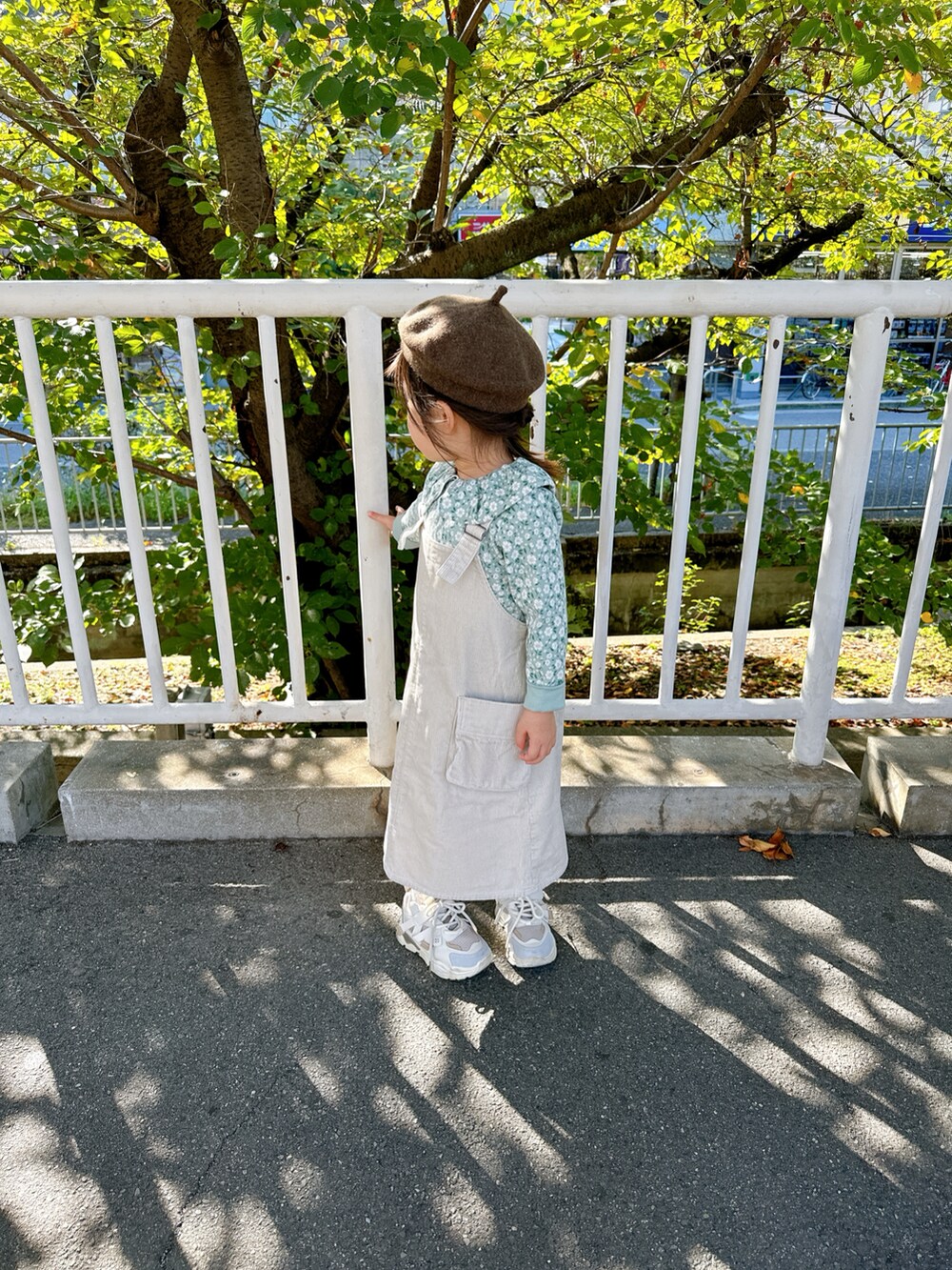 ホワイト系のジャンパースカート、グリーン系のTシャツ/カットソーを着用したキッズの秋コーディネートの2枚目の写真